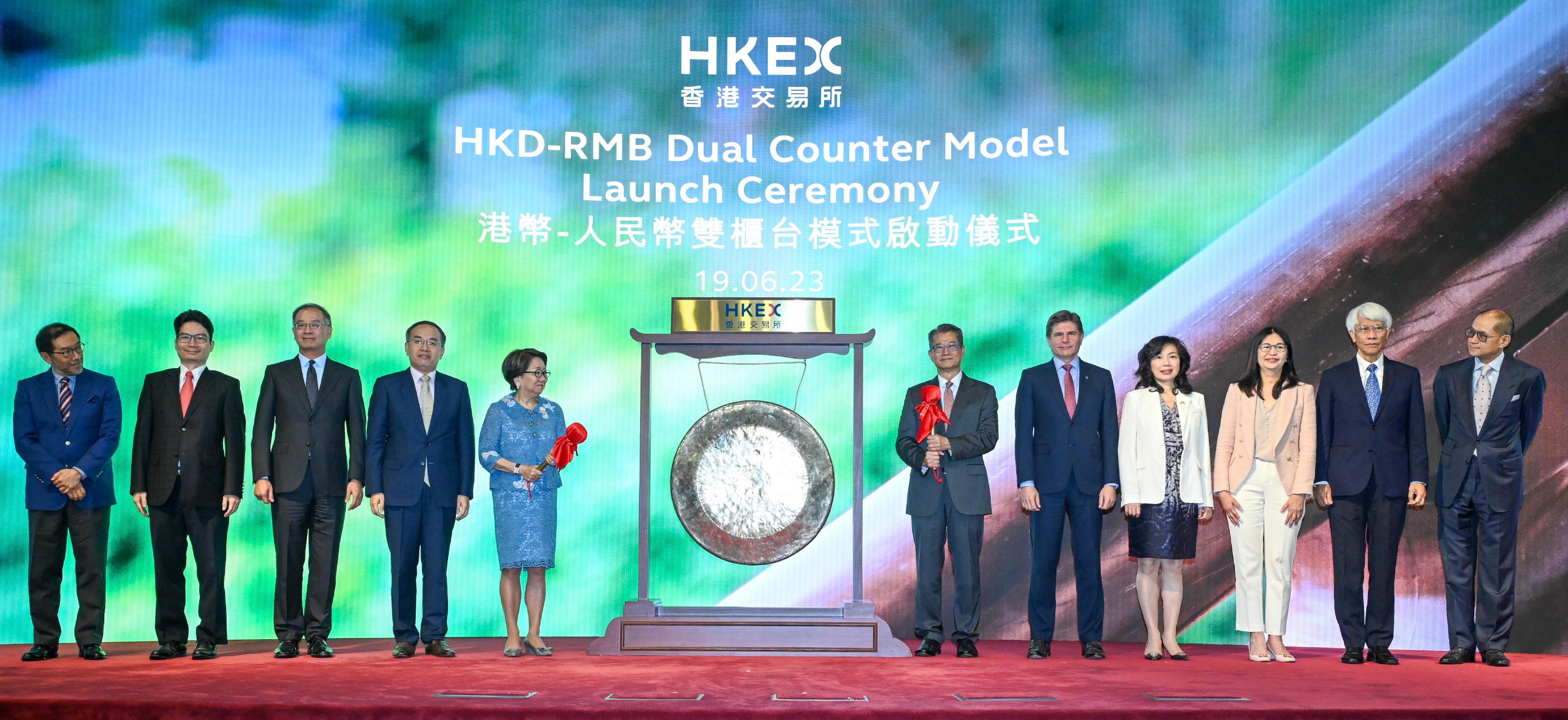 The Financial Secretary, Mr Paul Chan, attended the HKD-RMB Dual Counter Model Launch Ceremony today (June 19). Photo shows (from fourth left) the Secretary for Financial Services and the Treasury, Mr Christopher Hui; the Chairman of the Hong Kong Exchanges and Clearing Limited (HKEX), Mrs Laura Cha; Mr Chan; the Chief Executive Officer of the HKEX, Mr Nicolas Aguzin, and other guests at the ceremony.