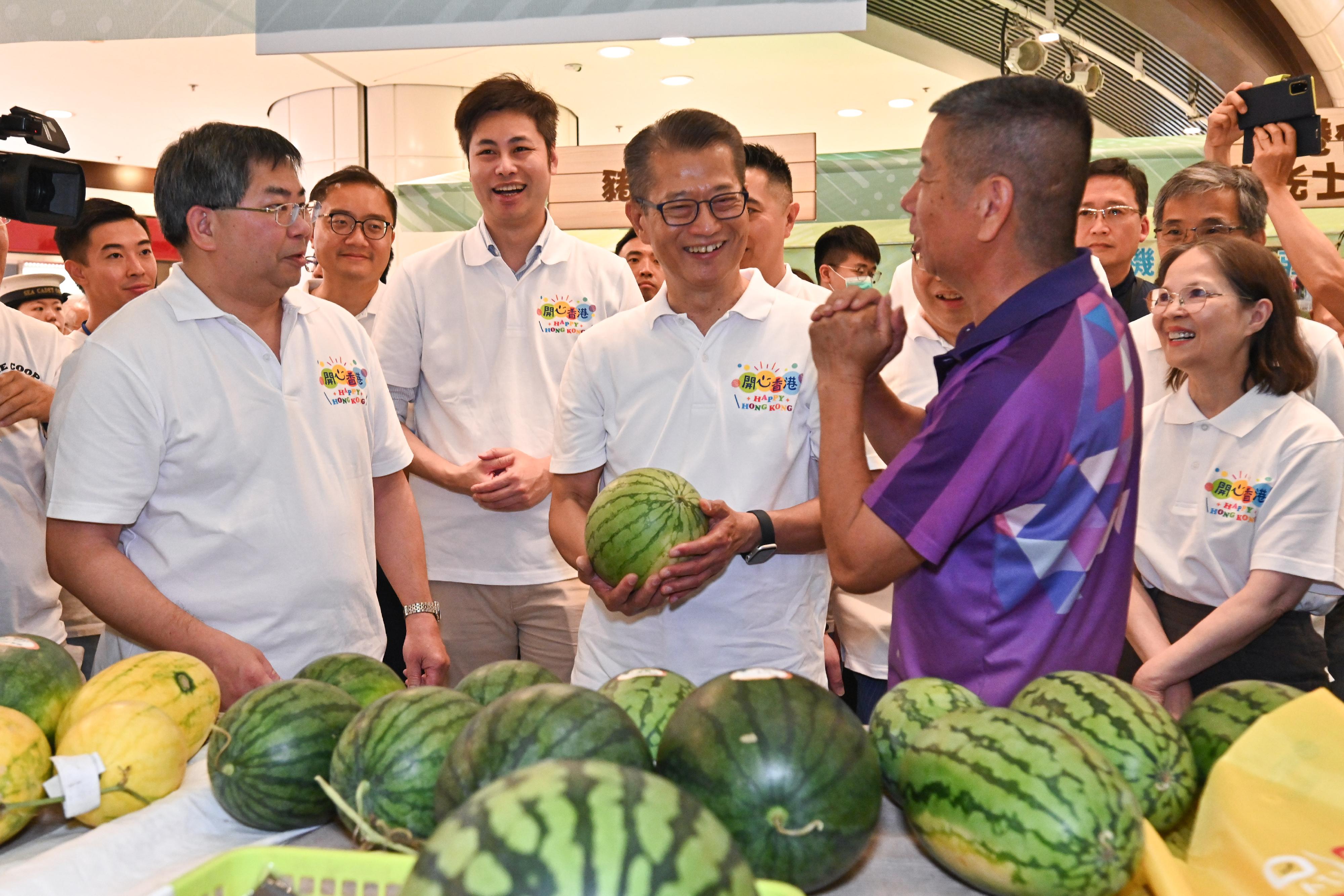 The Financial Secretary, Mr Paul Chan, attended the opening ceremony of the Happy Hong Kong - A and F Carnival: Local Organic Watermelon Festival 2023 today (June 22). Photo shows Mr Chan (third right), accompanied by the Under Secretary for Environment and Ecology, Miss Diane Wong (first right), and the Director of Agriculture, Fisheries and Conservation, Dr Leung Siu-fai (first left), touring the carnival.