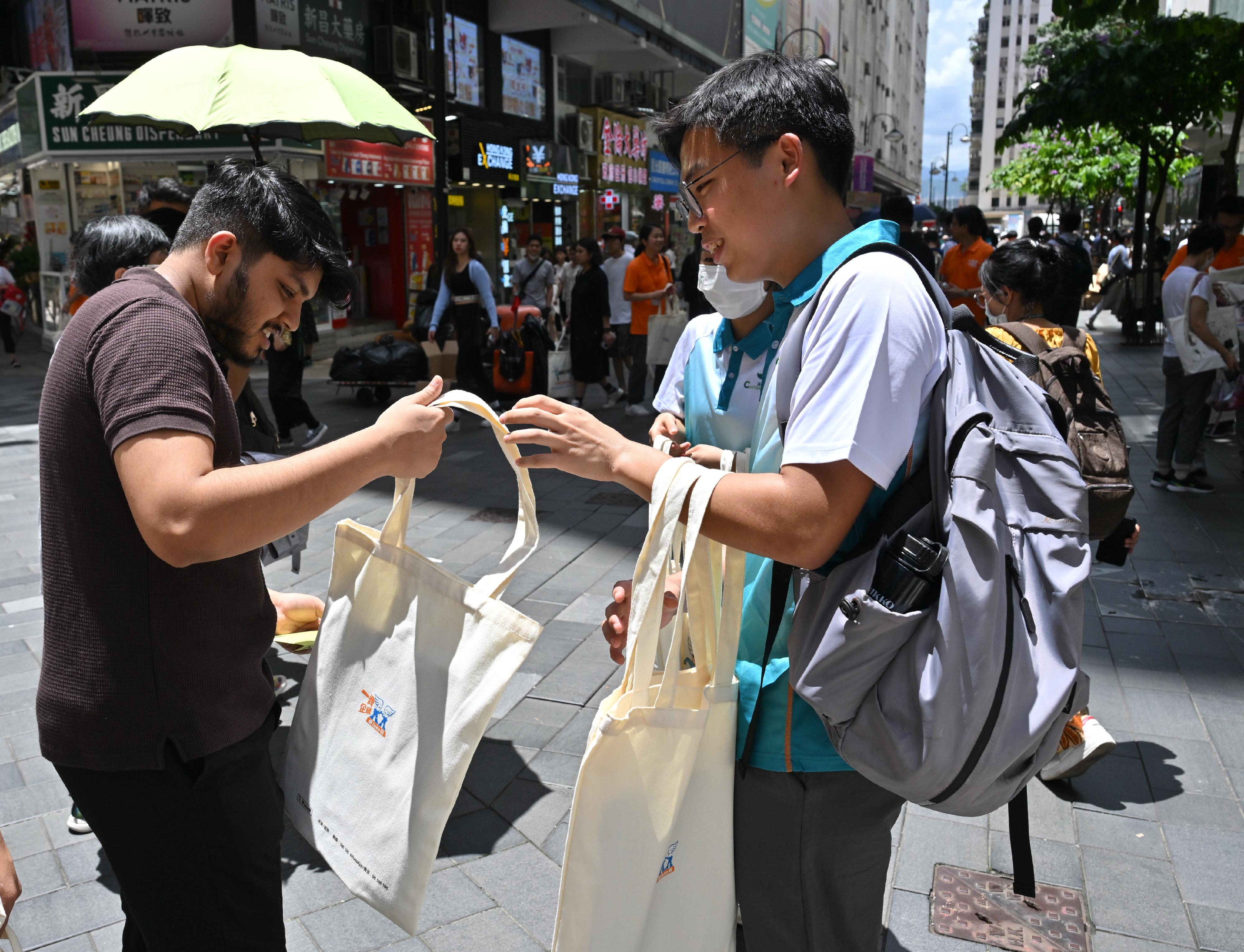 To echo the International Day against Drug Abuse and Illicit Trafficking, the Action Committee Against Narcotics held a preventive education and publicity event today (June 26) to unite different sectors of the community in the fight against drugs. Photo shows a youth member of "Customs YES" (right) distributing anti-drug leaflets and publicity items to members of the public, reminding them to firmly say no to drugs. 