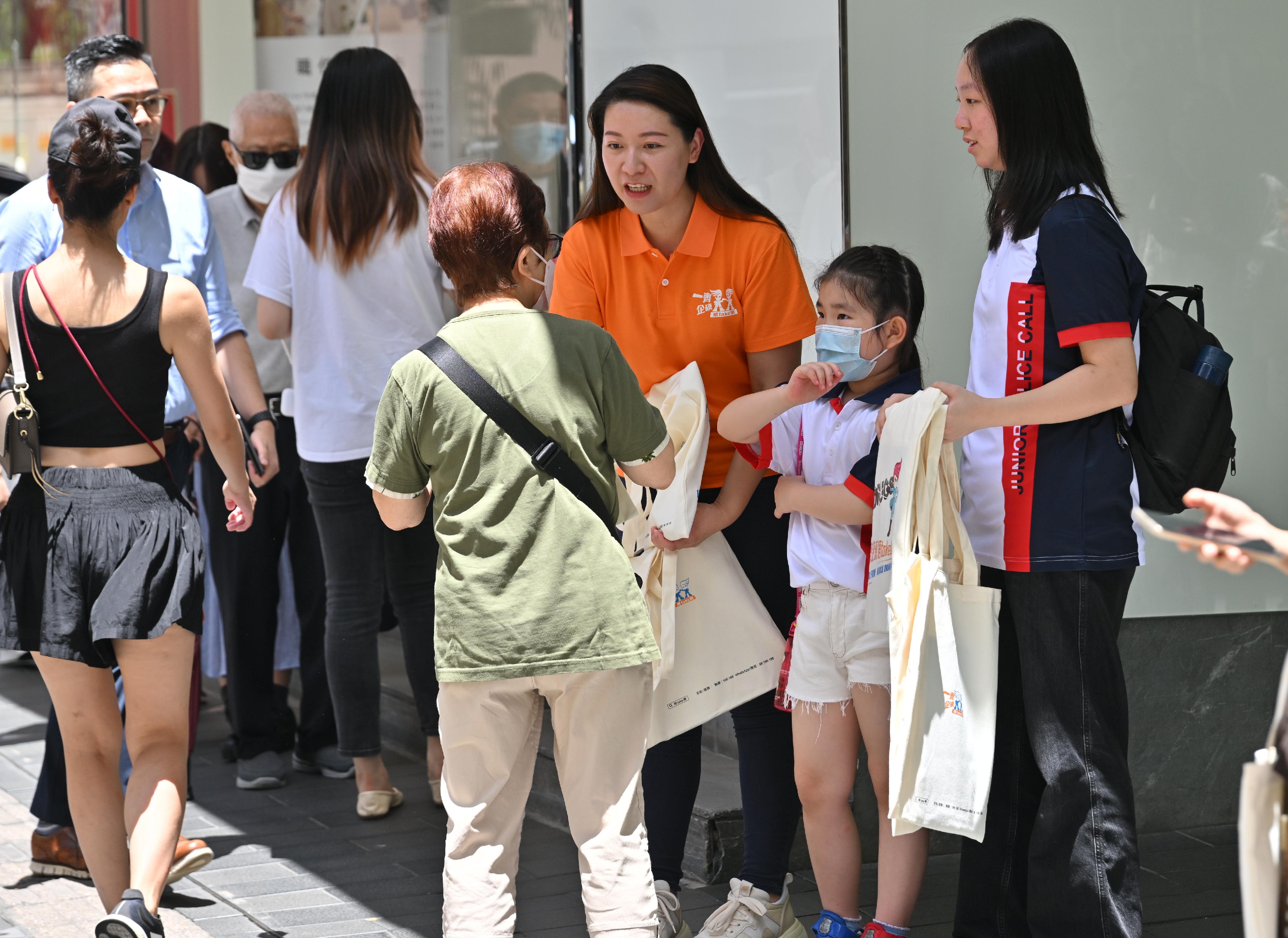 To echo the International Day against Drug Abuse and Illicit Trafficking, the Action Committee Against Narcotics held a preventive education and publicity event today (June 26) to unite different sectors of the community in the fight against drugs. Photo shows members of the Junior Police Call (first right and second right) distributing anti-drug leaflets and publicity items to members of the public, reminding them to firmly say no to drugs. 