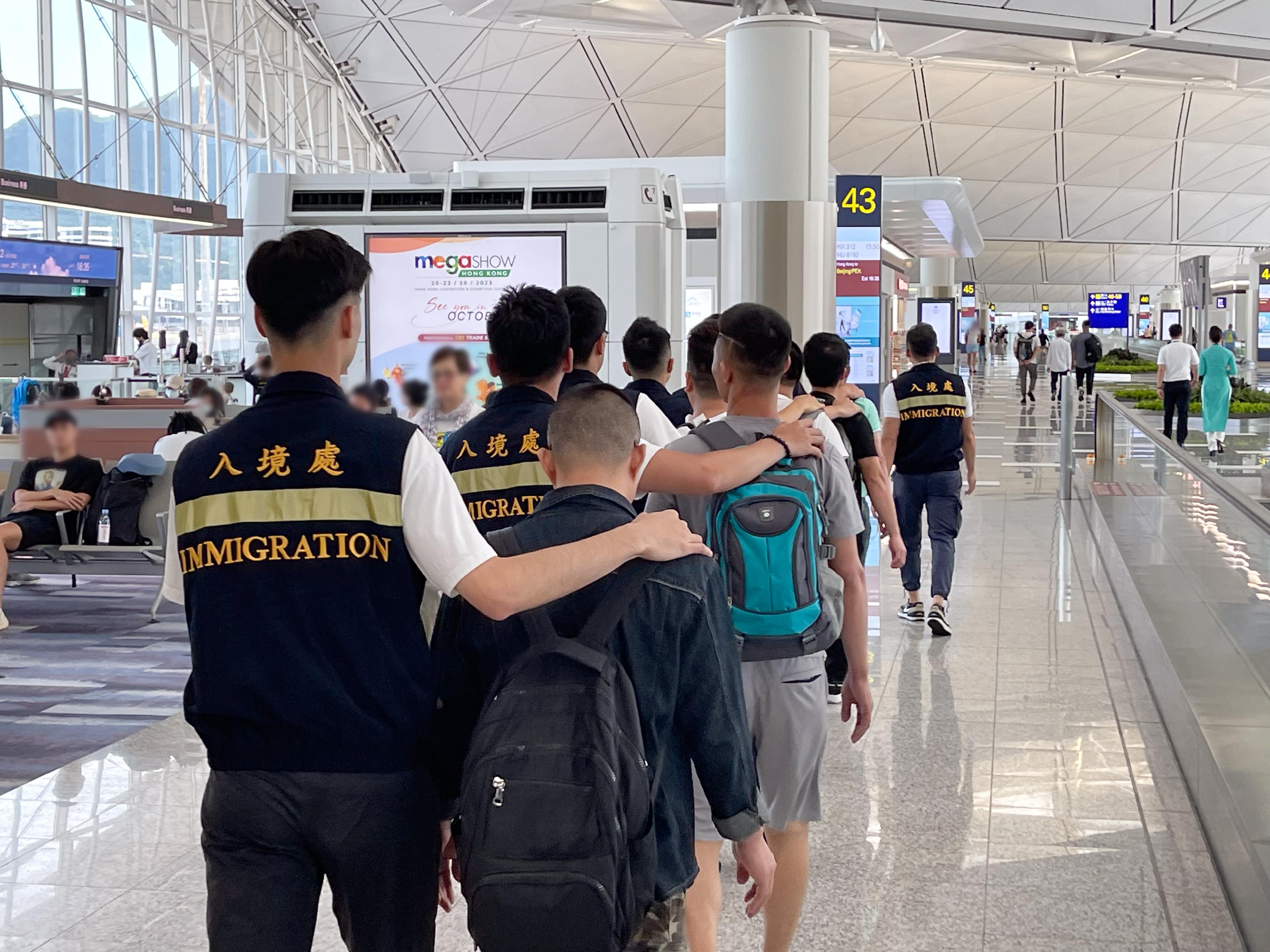 入境事務處（入境處）今日（六月二十八日）執行遣送行動，將33名越南籍非法入境者遣返越南。圖示被遣返人士在入境處人員押送下離港。