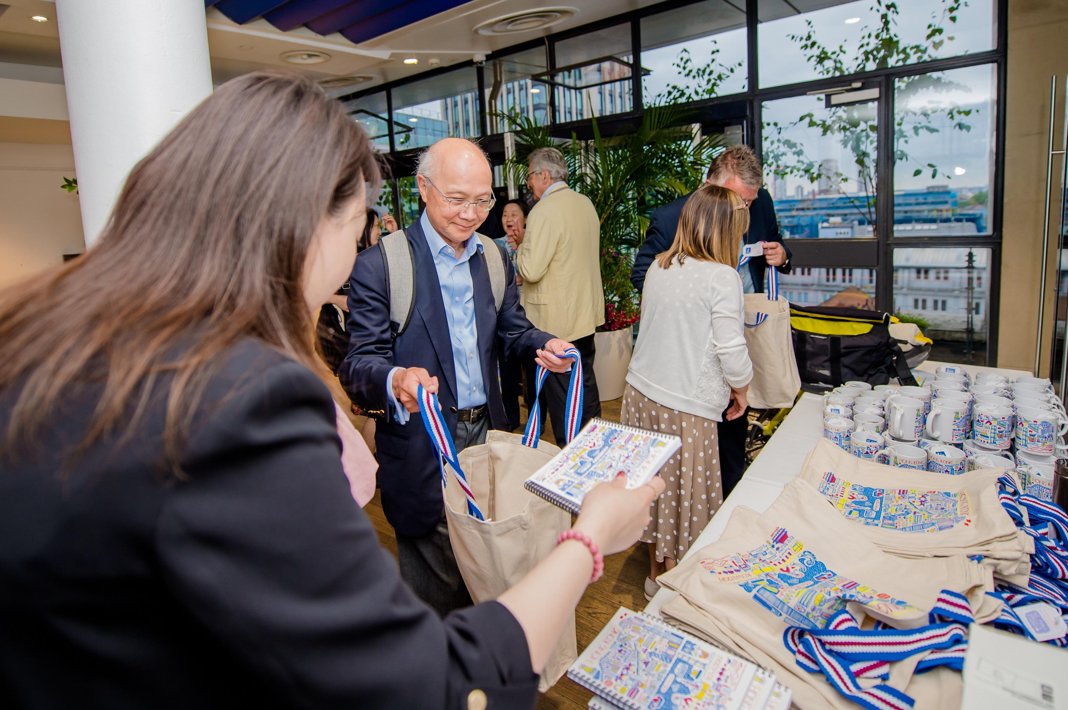 The Hong Kong Economic and Trade Office, London (London ETO) hosted a summer networking reception in London, United Kingdom, on June 27 (London time), greeting about 200 guests. Photo shows staff of London ETO presenting souvenirs with Hong Kong features to guests.