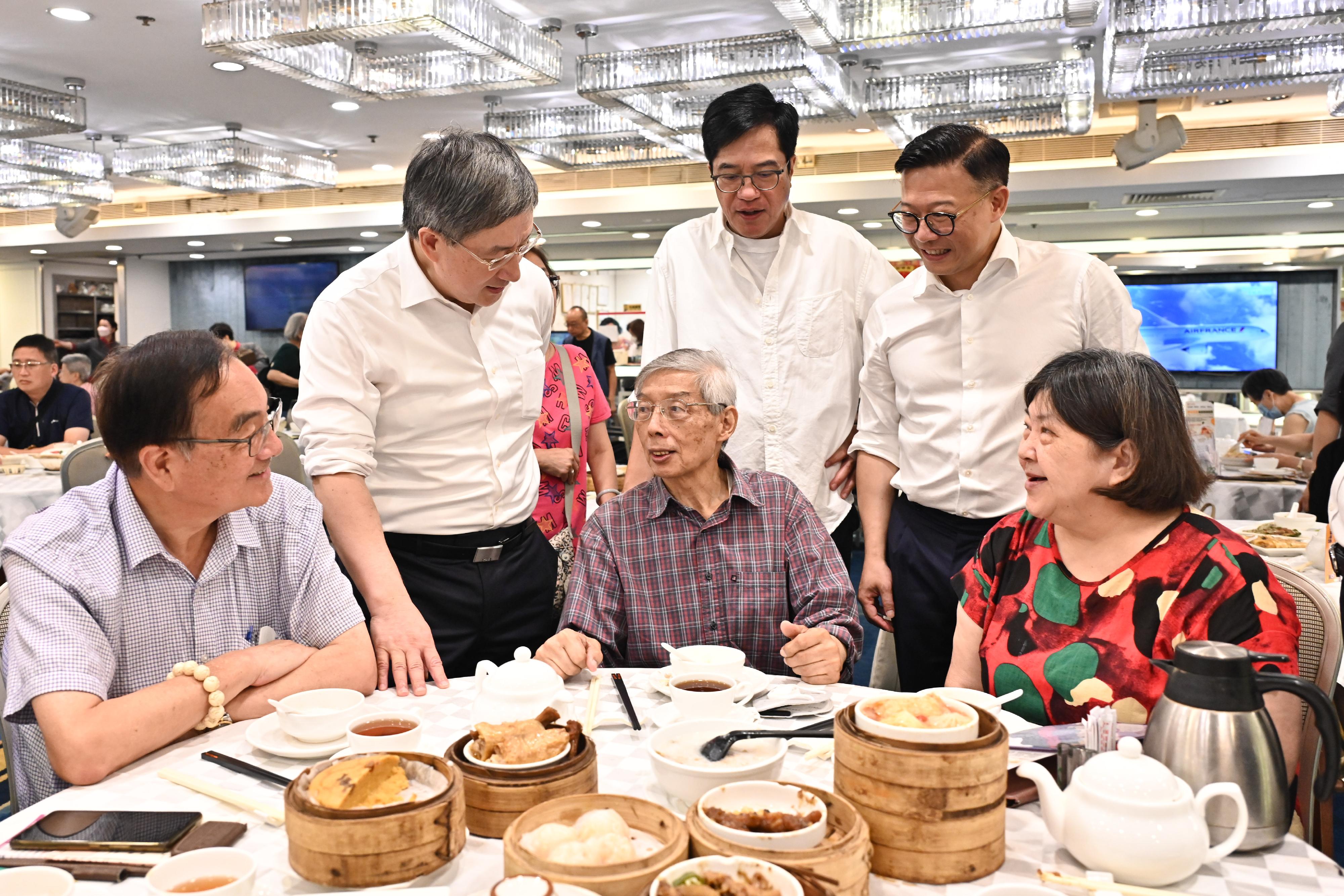 The Deputy Chief Secretary for Administration, Mr Cheuk Wing-hing (back row, left); the Deputy Financial Secretary, Mr Michael Wong (back row, centre); and the Deputy Secretary for Justice, Mr Cheung Kwok-kwan (back row, right), are glad to learn that members of the public welcome the special offers in celebration of Hong Kong's return to the motherland at a North Point restaurant today (July 1).
