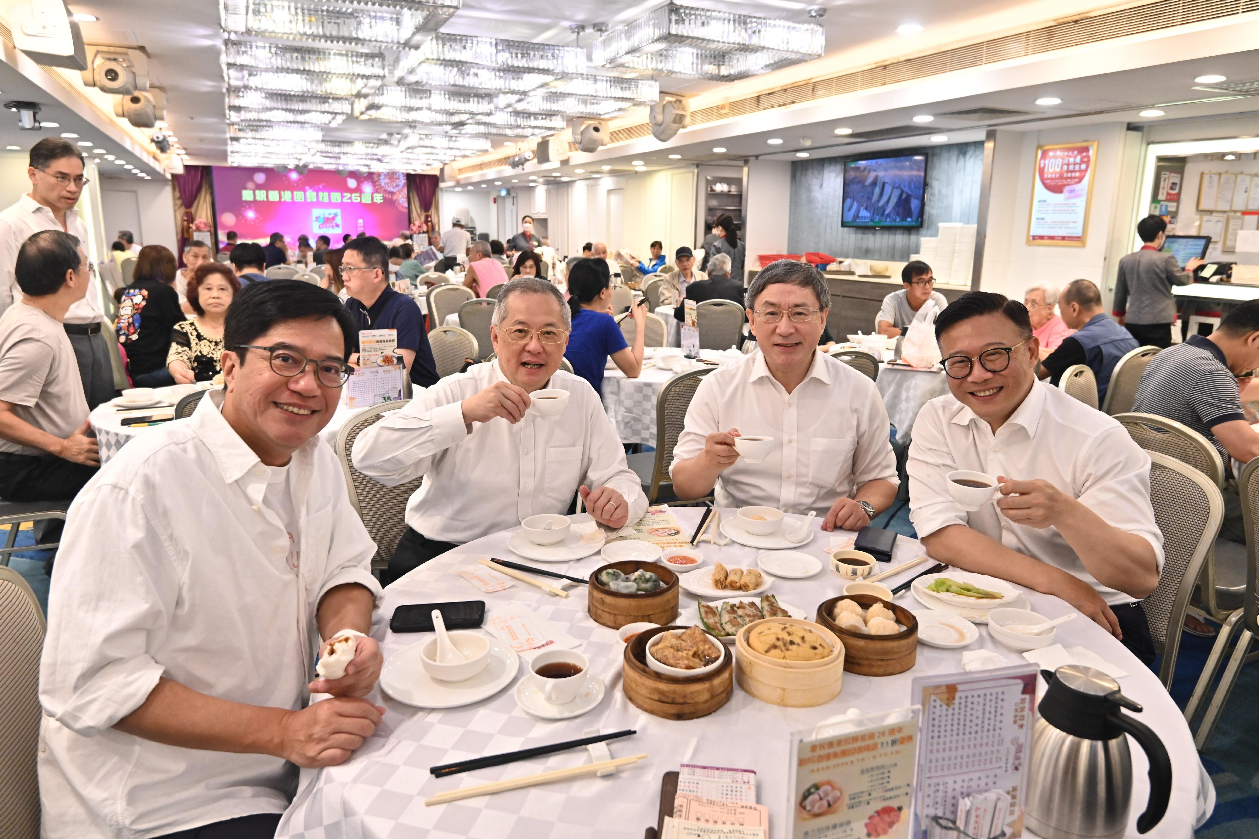 The Deputy Chief Secretary for Administration, Mr Cheuk Wing-hing (second right); the Deputy Financial Secretary, Mr Michael Wong (first left); and the Deputy Secretary for Justice, Mr Cheung Kwok-kwan (first right),  together with the Legislative Council Member (Catering), Mr Tommy Cheung (second left), enjoy dim sum at a North Point restaurant today (July 1) to celebrate Hong Kong's return to the motherland.