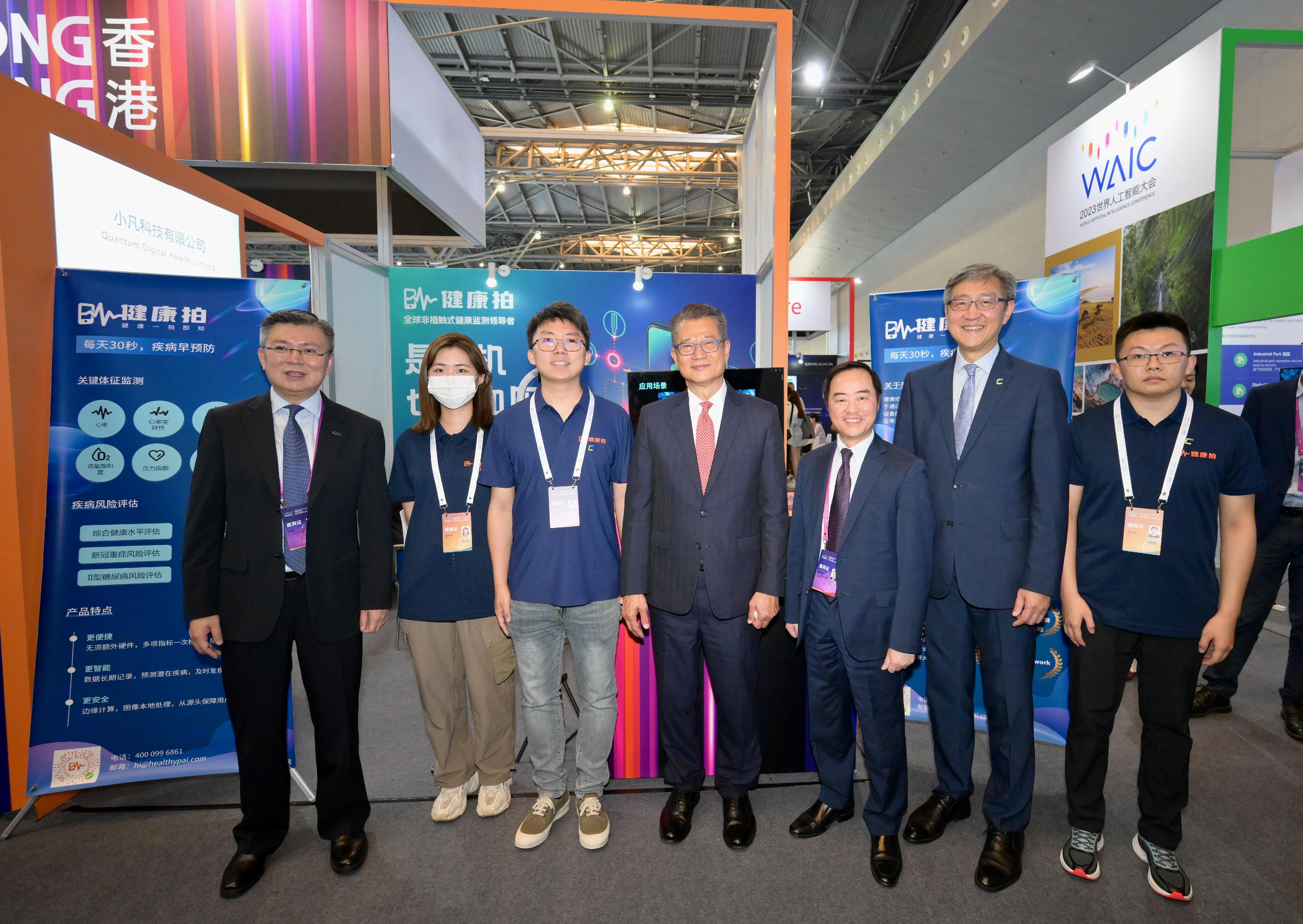 財政司司長陳茂波今日（七月六日）繼續上海訪問行程。圖示陳茂波（中）與2023世界人工智能大會展覽的香港館參展商合照。