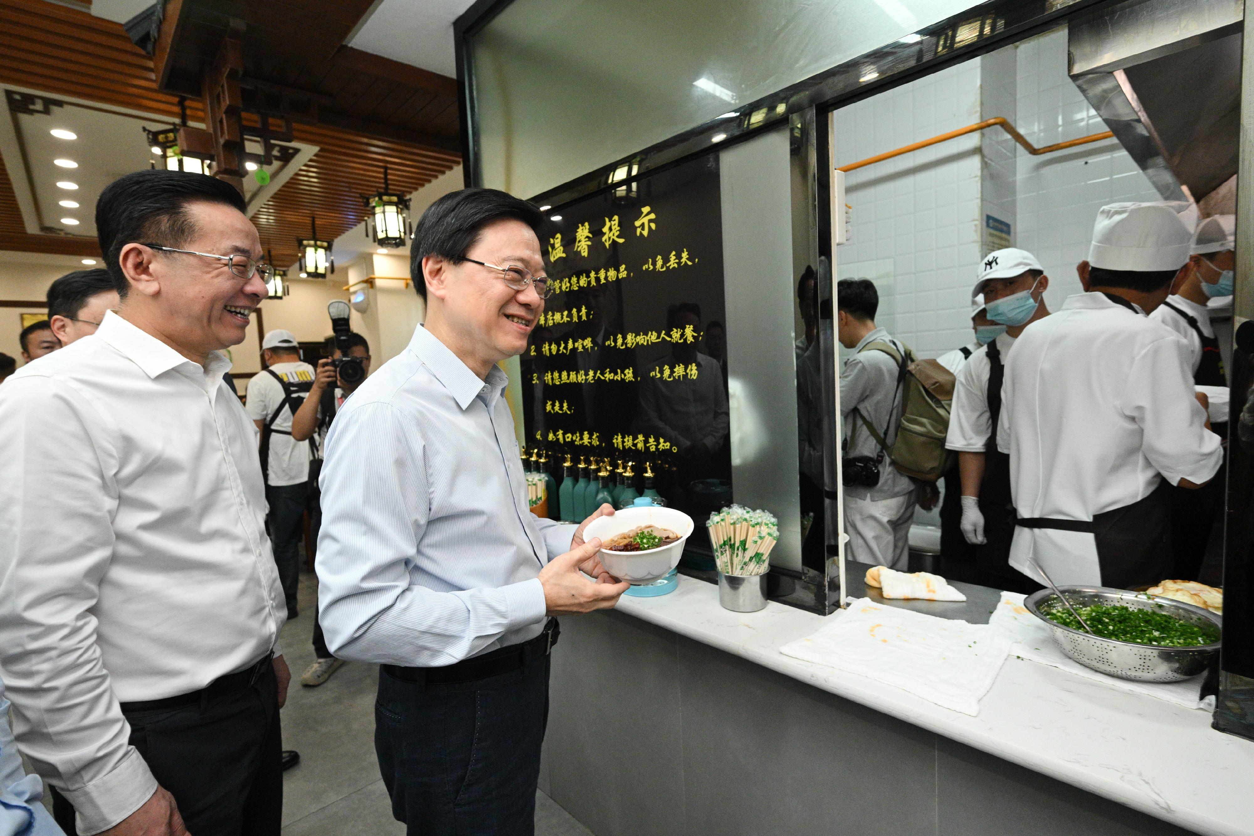 The Chief Executive, Mr John Lee, led a delegation to start his visit programme in Guiyang today (July 6). Photo shows Mr Lee (second left), accompanied by member of the Standing Committee and Head of the Publicity Department of the Guizhou CPC Provincial Committee, Mr Lu Yongzheng (first left), having breakfast in a local restaurant.