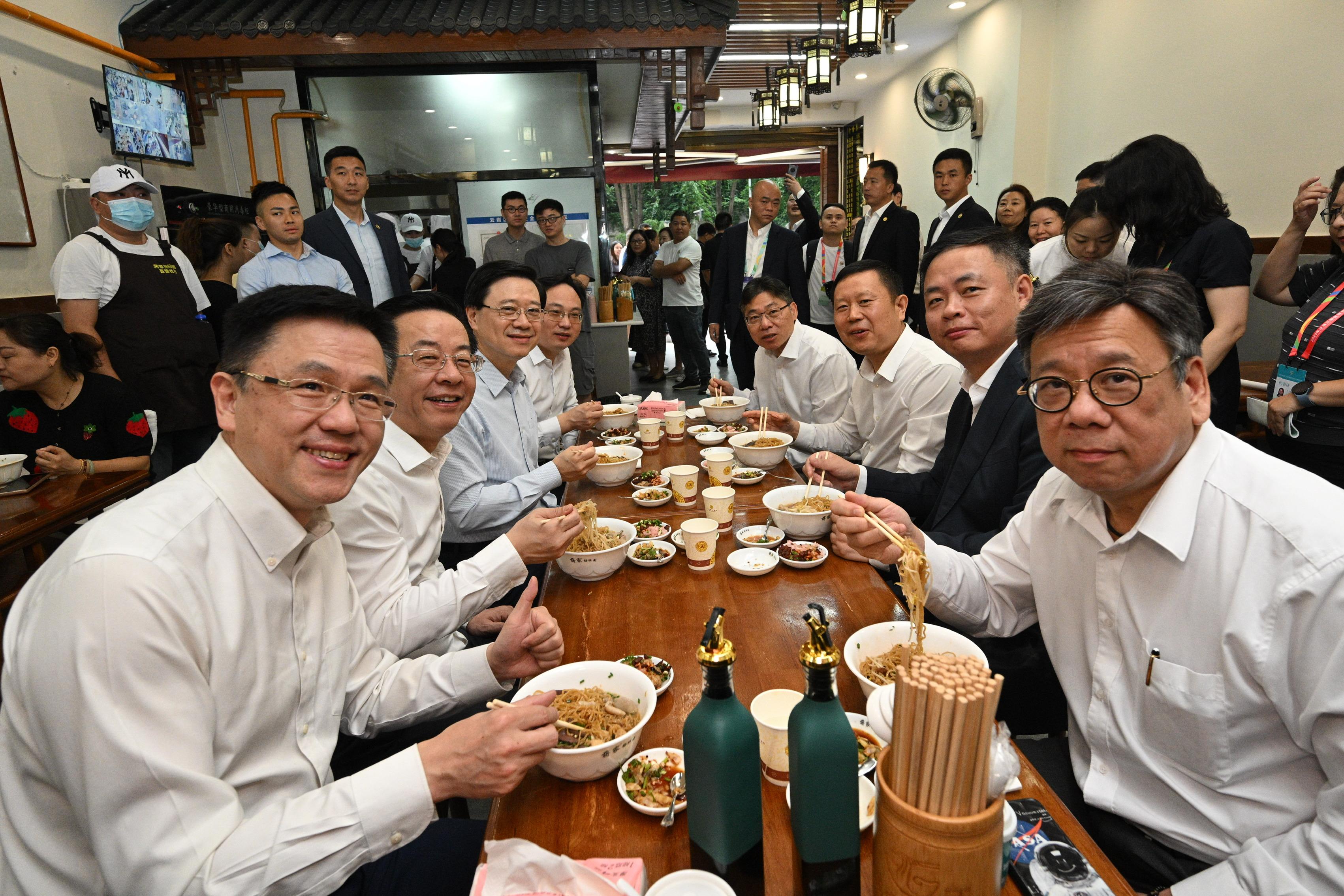 The Chief Executive, Mr John Lee, led a delegation to start his visit programme in Guiyang today (July 6). Photo shows Mr Lee (third left); member of the Standing Committee and Head of the Publicity Department of the Guizhou CPC Provincial Committee, Mr Lu Yongzheng (second left); the Secretary for Commerce and Economic Development, Mr Algernon Yau (first right); the Secretary for Transport and Logistics, Mr Lam Sai-hung (fourth right); and the Secretary for Innovation, Technology and Industry, Professor Sun Dong (first left), having breakfast in a local restaurant.