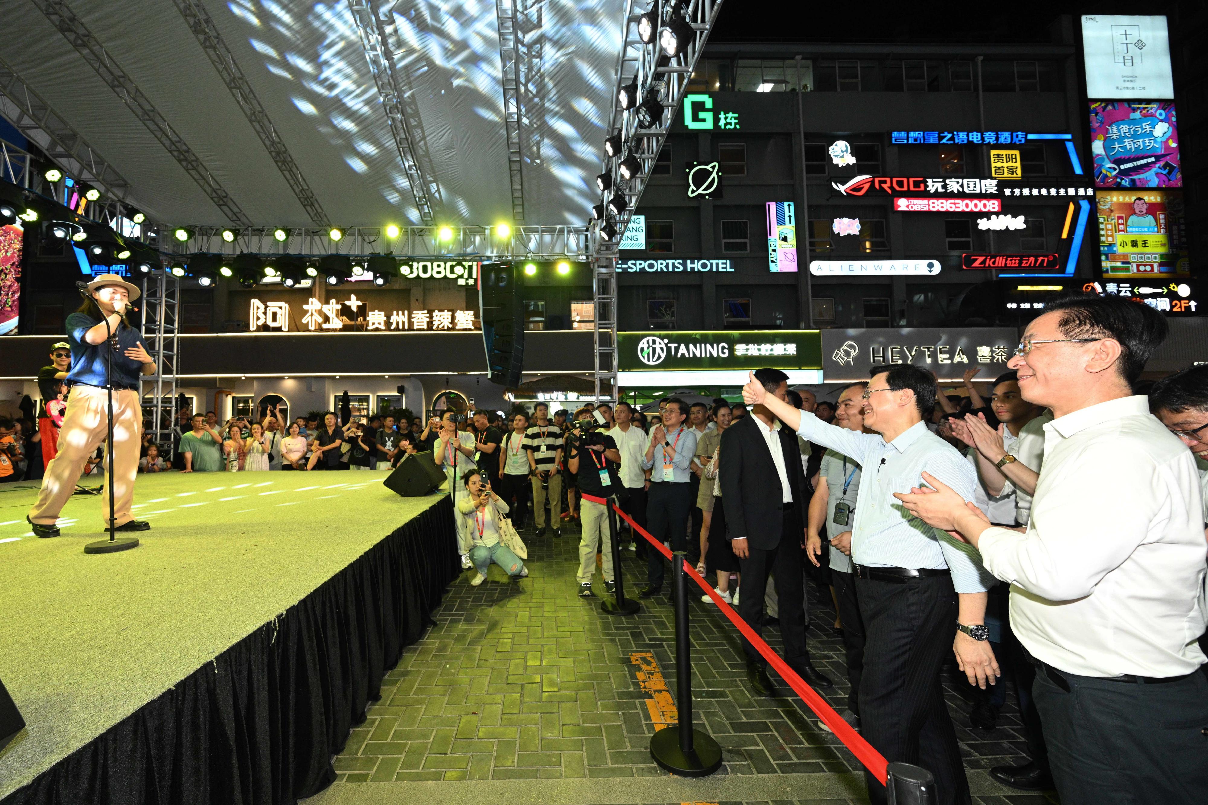 The Chief Executive, Mr John Lee, led a delegation to start his visit programme in Guiyang, today (July 6). Photo shows Mr Lee (right), accompanied by member of the Standing Committee and Head of the Publicity Department of the Guizhou CPC Provincial Committee, Mr Lu Yongzheng (first right), watching band performance at the Qingyun Market.