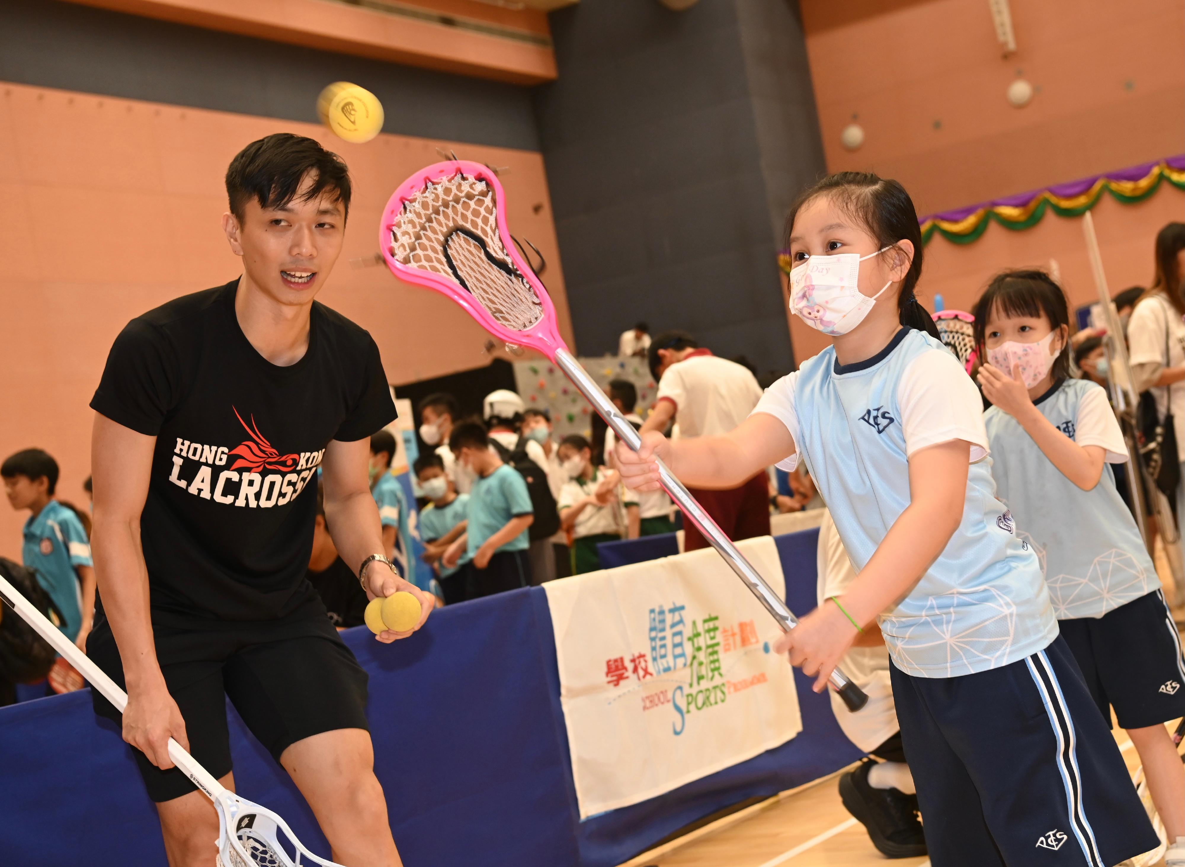 康乐及文化事务署今日（七月七日）在中山纪念公园体育馆举行2023学校体育推广计划颁奖典礼暨嘉年华。图示学生参与棍网球运动同乐活动。