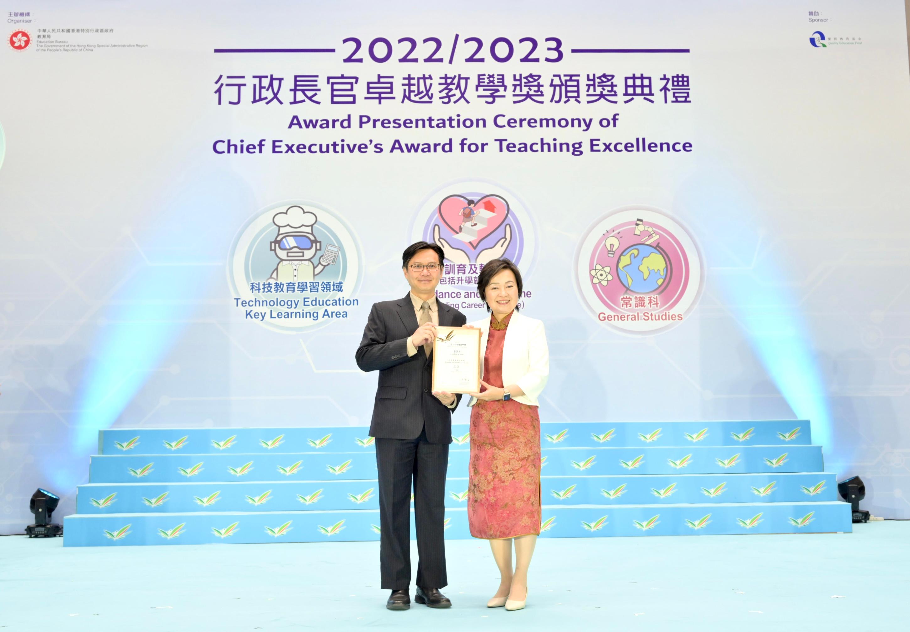 The Secretary for Education, Dr Choi Yuk-lin (right), presents a Certificate of Merit at the Award Presentation Ceremony of the Chief Executive's Award for Teaching Excellence today (July 7).