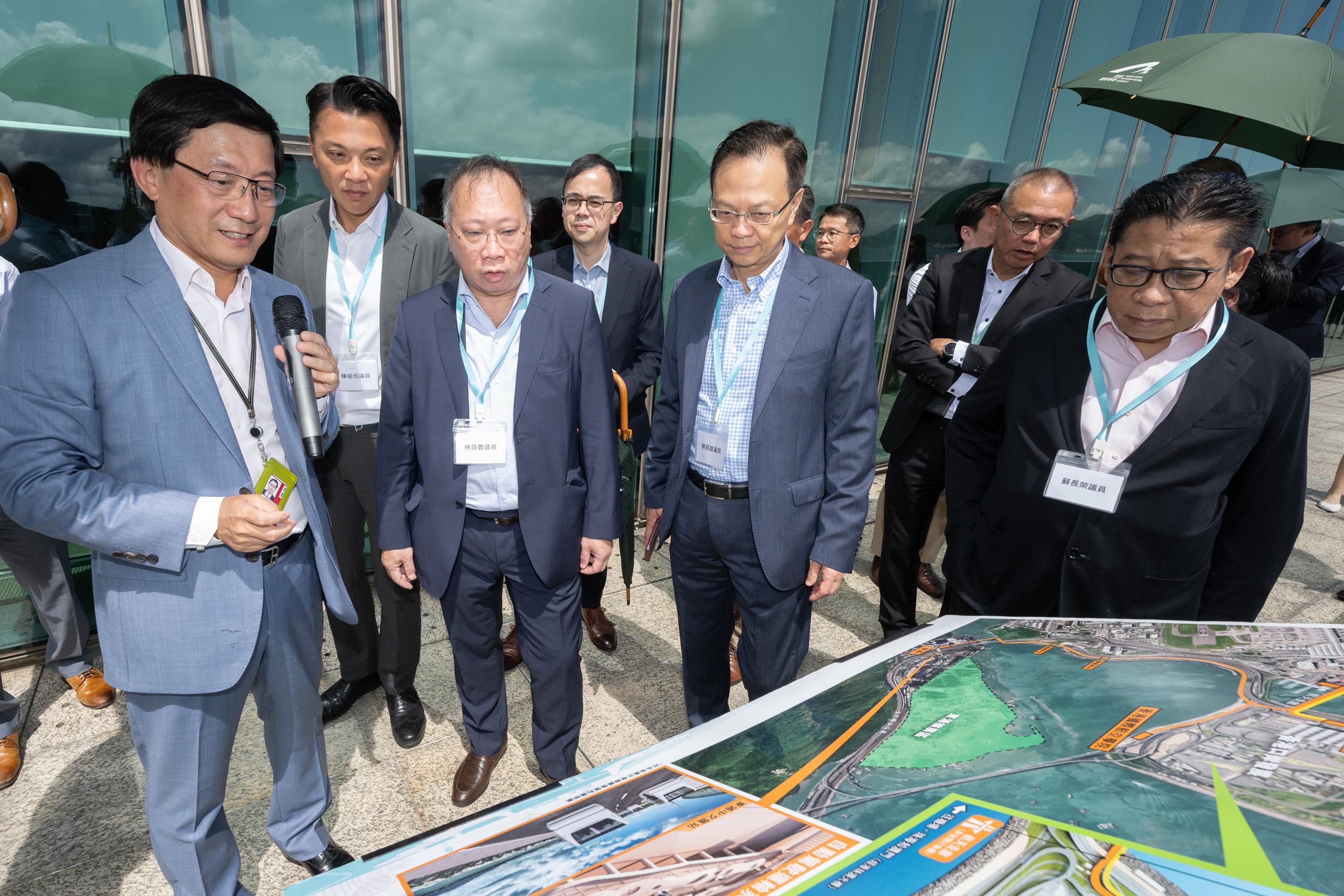 立法会经济发展事务委员会今日（七月十一日）参观香港国际机场。图示委员会主席陈祖恒（左二）、副主席苏长荣（右一）和其他议员听取香港机场管理局行政总裁林天福（左一）介绍机场各发展项目。