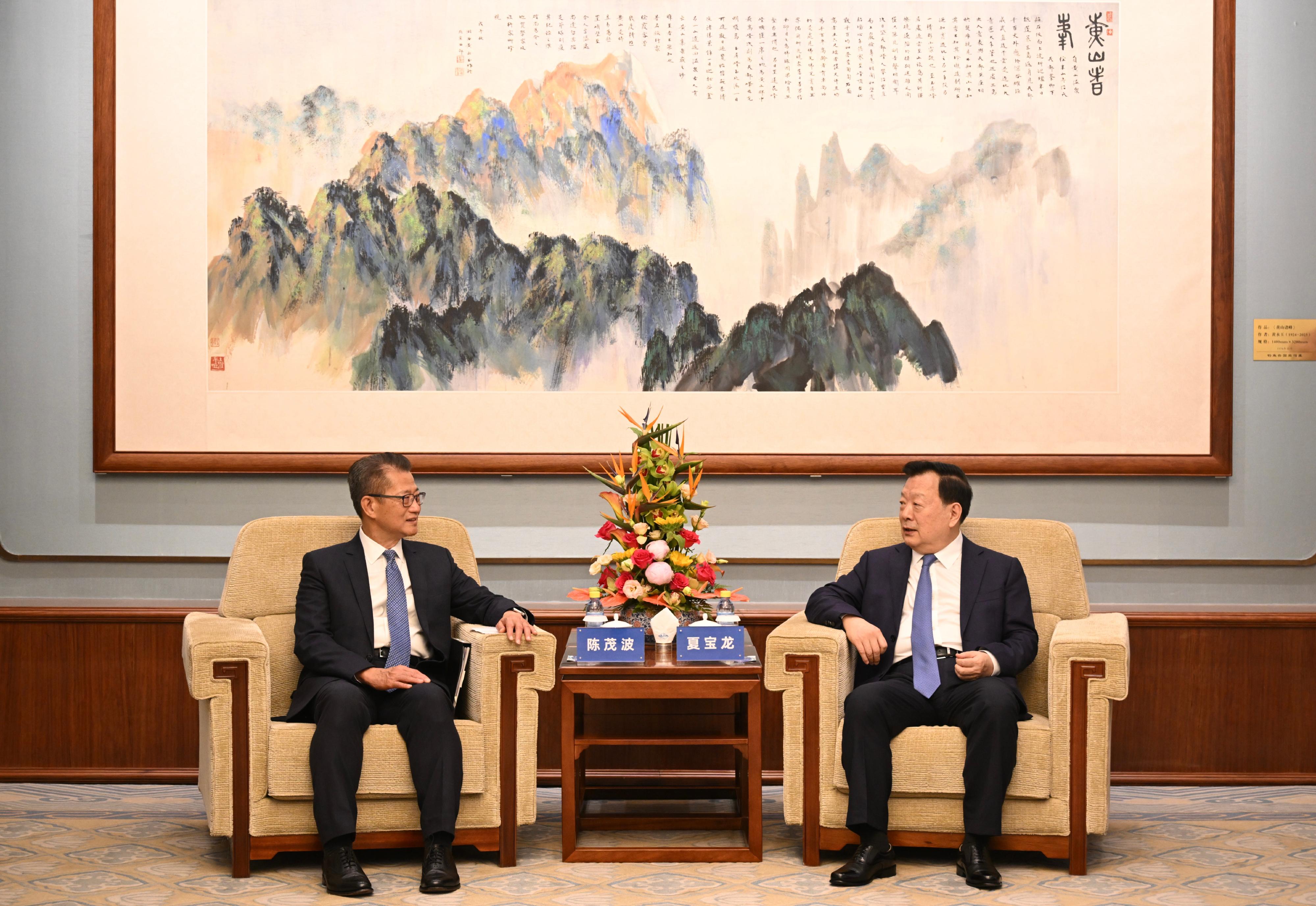 財政司司長陳茂波今日（七月十二日）繼續訪問北京的行程。圖示國務院港澳辦公室主任夏寶龍（右）今日早上會見陳茂波。