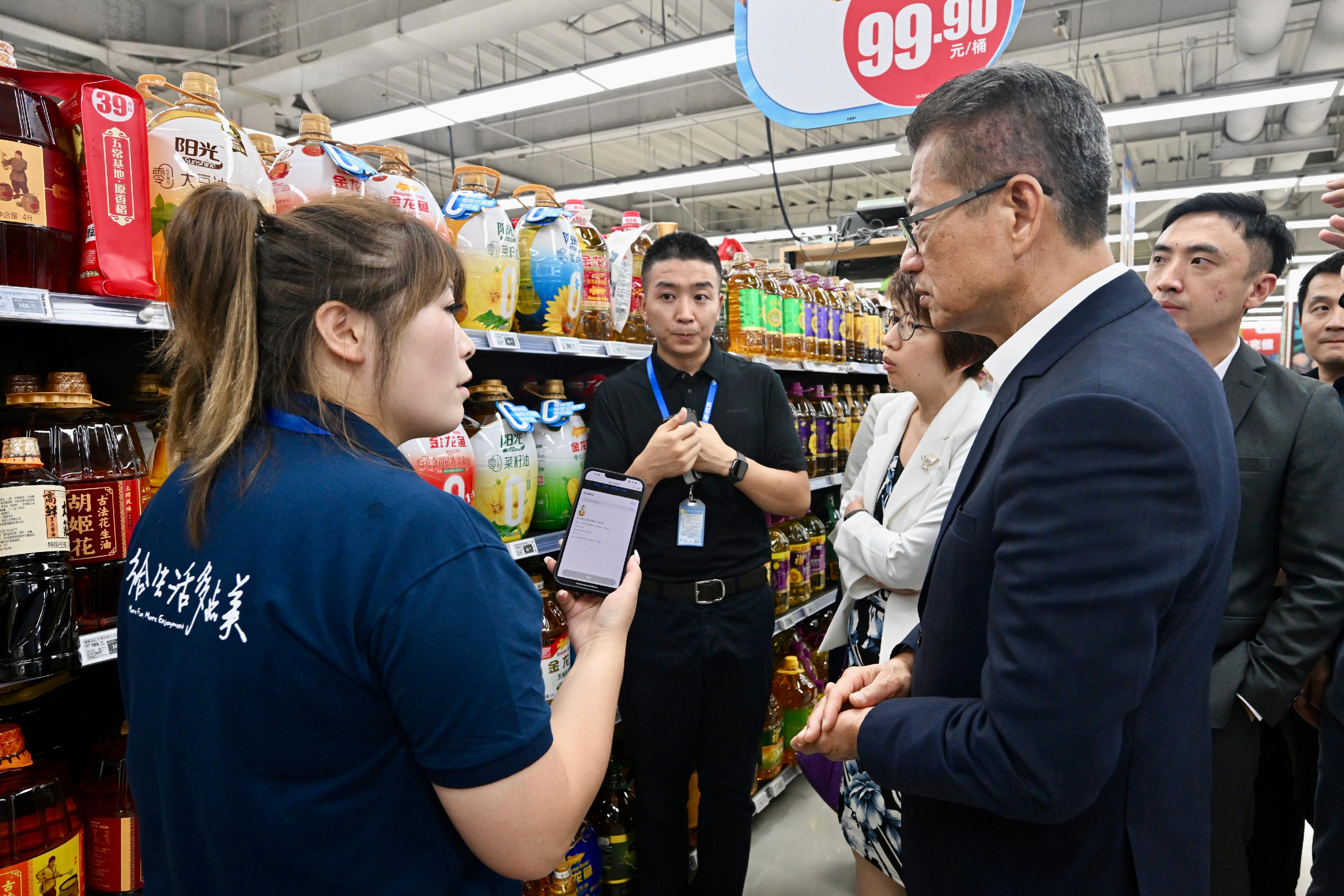 財政司司長陳茂波今日（七月十二日）繼續訪問北京的行程。圖示陳茂波（右）參觀一家領先的零售雲解決方案服務商旗下超市。