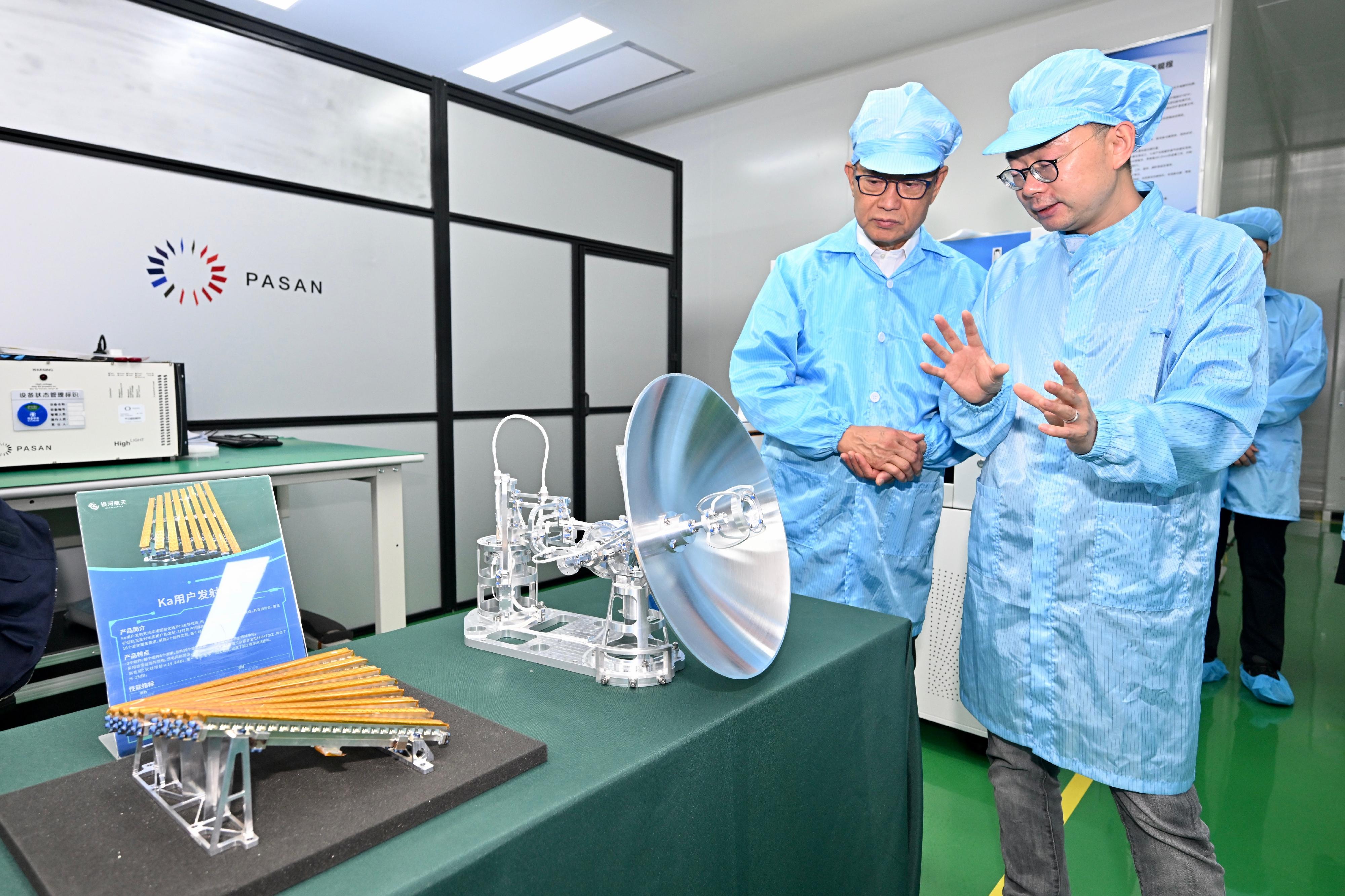 The Financial Secretary, Mr Paul Chan, continued his visit in Beijing today (July 12). Photo shows Mr Chan (left) visiting an enterprise which manufactures satellites and offers satellite Internet solutions. He toured its research and development centre and viewed new generation satellite products.