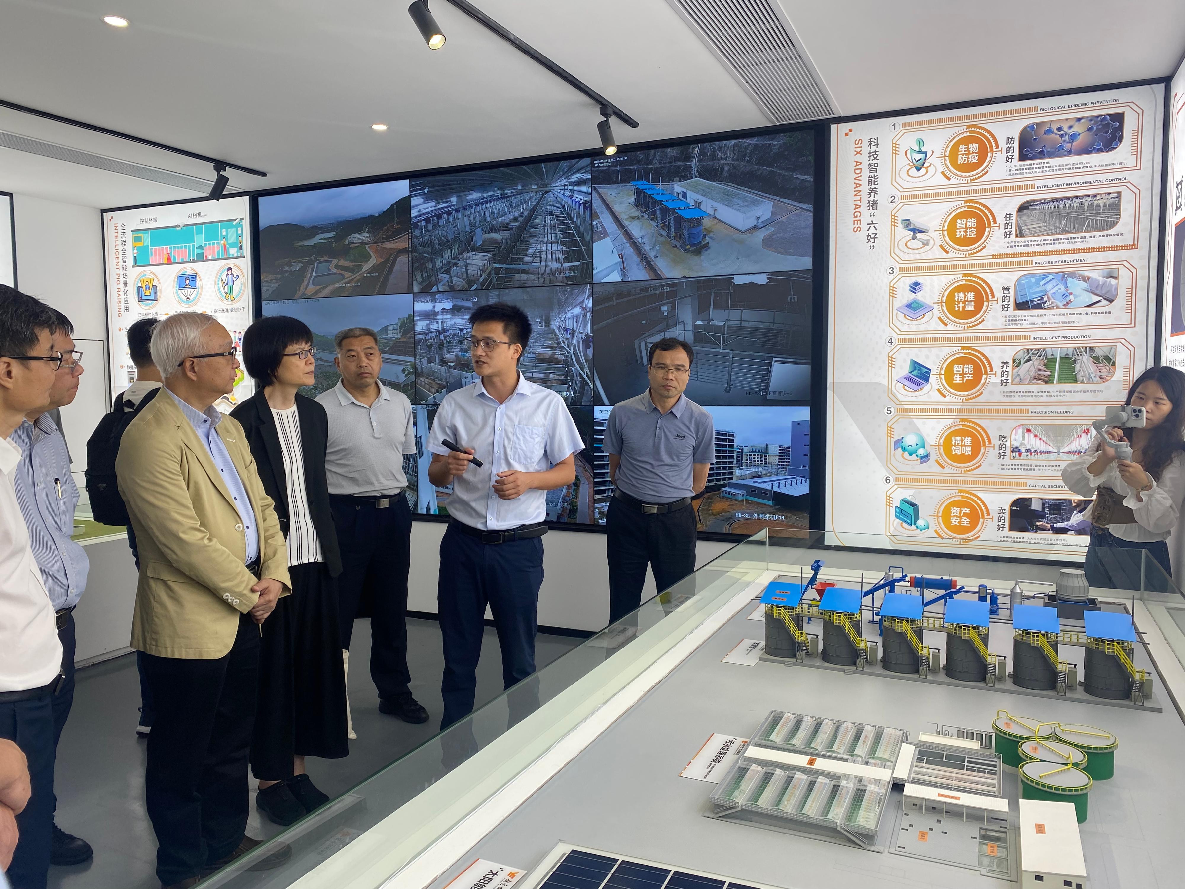 The Secretary for Environment and Ecology, Mr Tse Chin-wan, began his visit in Guangzhou and Zhaoqing today (July 18) and visited a high-rise pig farm in Huadu District in Guangzhou in the afternoon. Photo shows Mr Tse (third left); the Permanent Secretary for Environment and Ecology (Food), Miss Vivian Lau (fourth left); and the Director of Agriculture, Fisheries and Conservation, Dr Leung Siu-fai (second left), receiving a briefing from a representative of the farm on technologies and operation of the multi-storey livestock farm facilities. 

