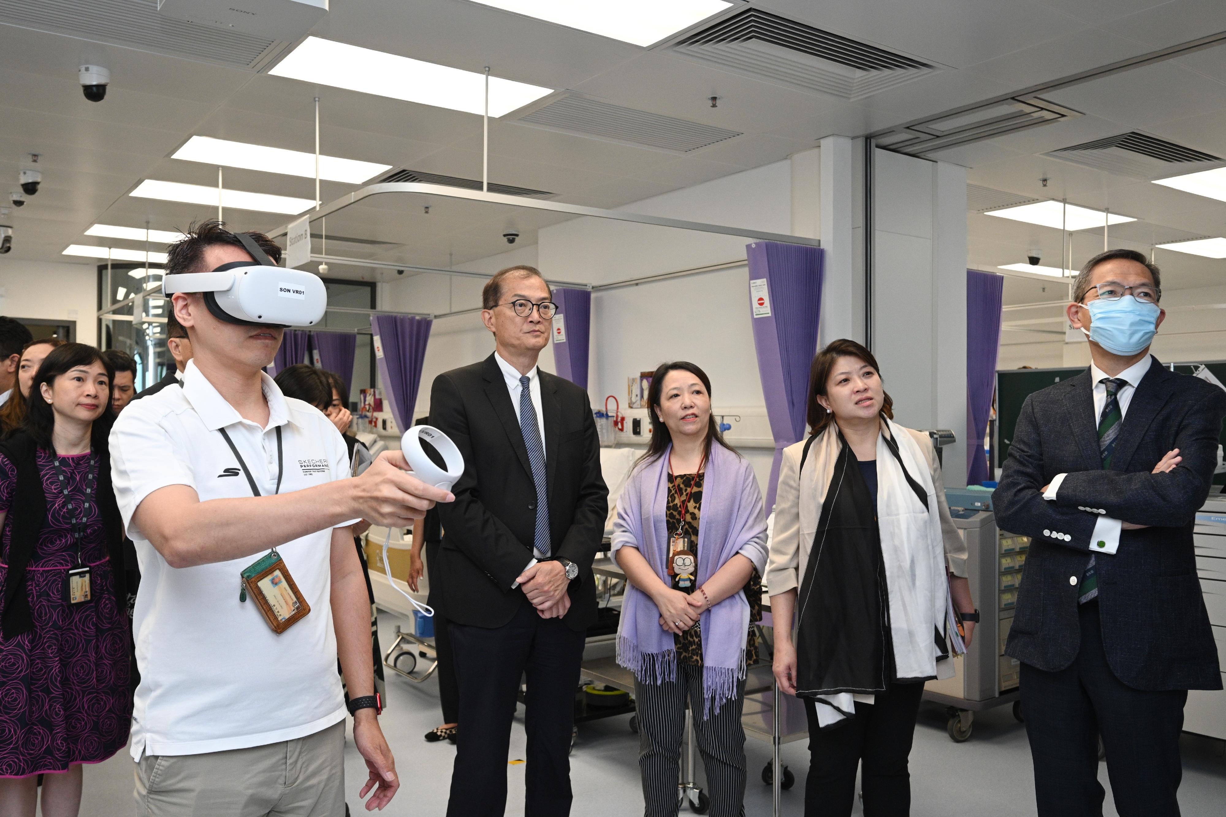 The Secretary for Health, Professor Lo Chung-mau (fourth right), and the Under Secretary for Health, Dr Libby Lee (second right), pay a visit to the Li Ka Shing Faculty of Medicine of the University of Hong Kong (HKUMed) today (July 19) and observe a staff demonstration of how students practise nursing procedures with the use of virtual reality devices. Looking on is the Dean of the HKUMed, Professor Lau Chak-sing (first right).

