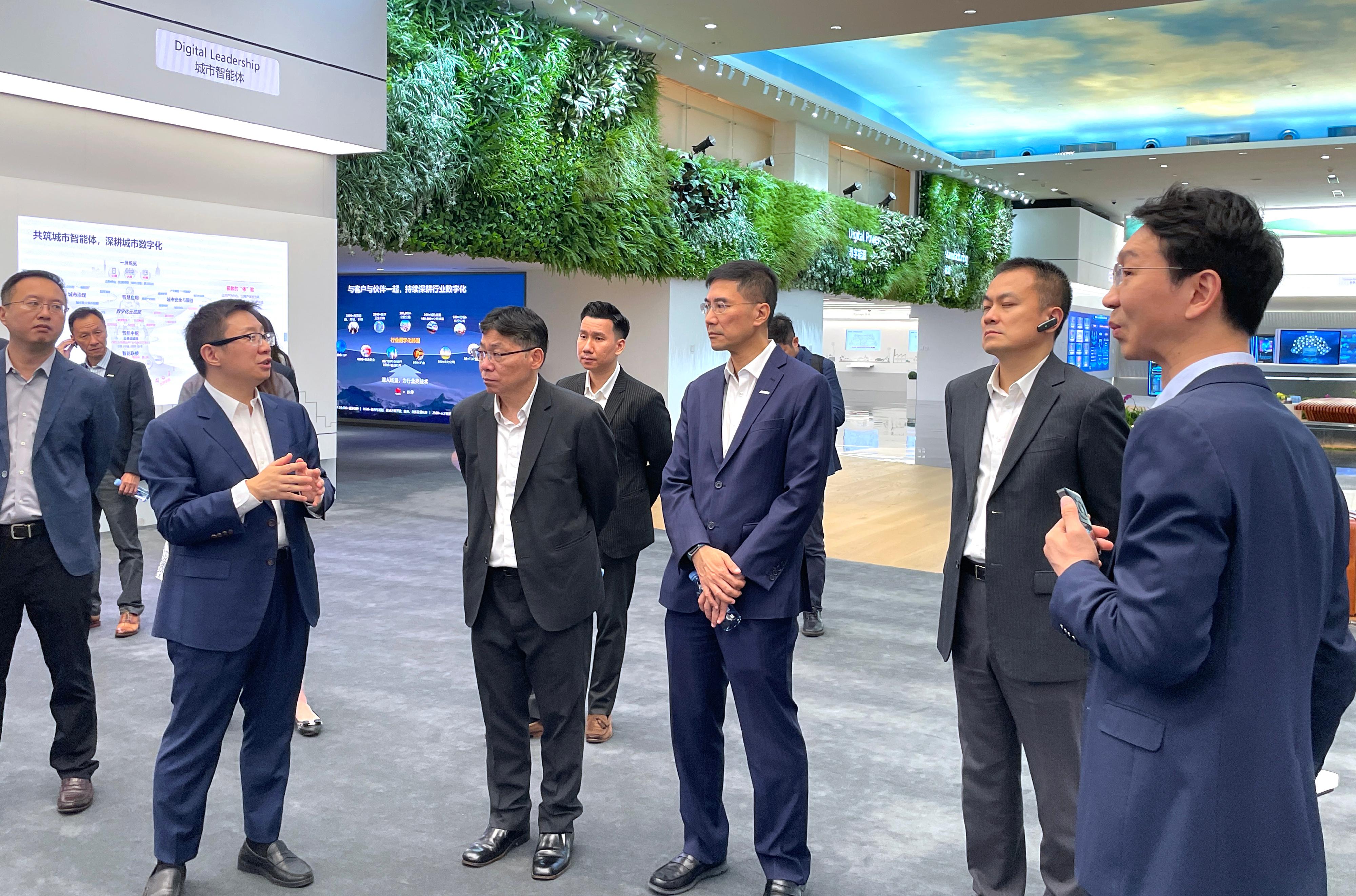 The Secretary for Transport and Logistics, Mr Lam Sai-hung, visited the headquarters of Huawei in Shenzhen today (July 19). Photo shows Mr Lam (third left) being briefed by a Huawei representative on the functionalities and technological development of its integrated smart traffic control platform.