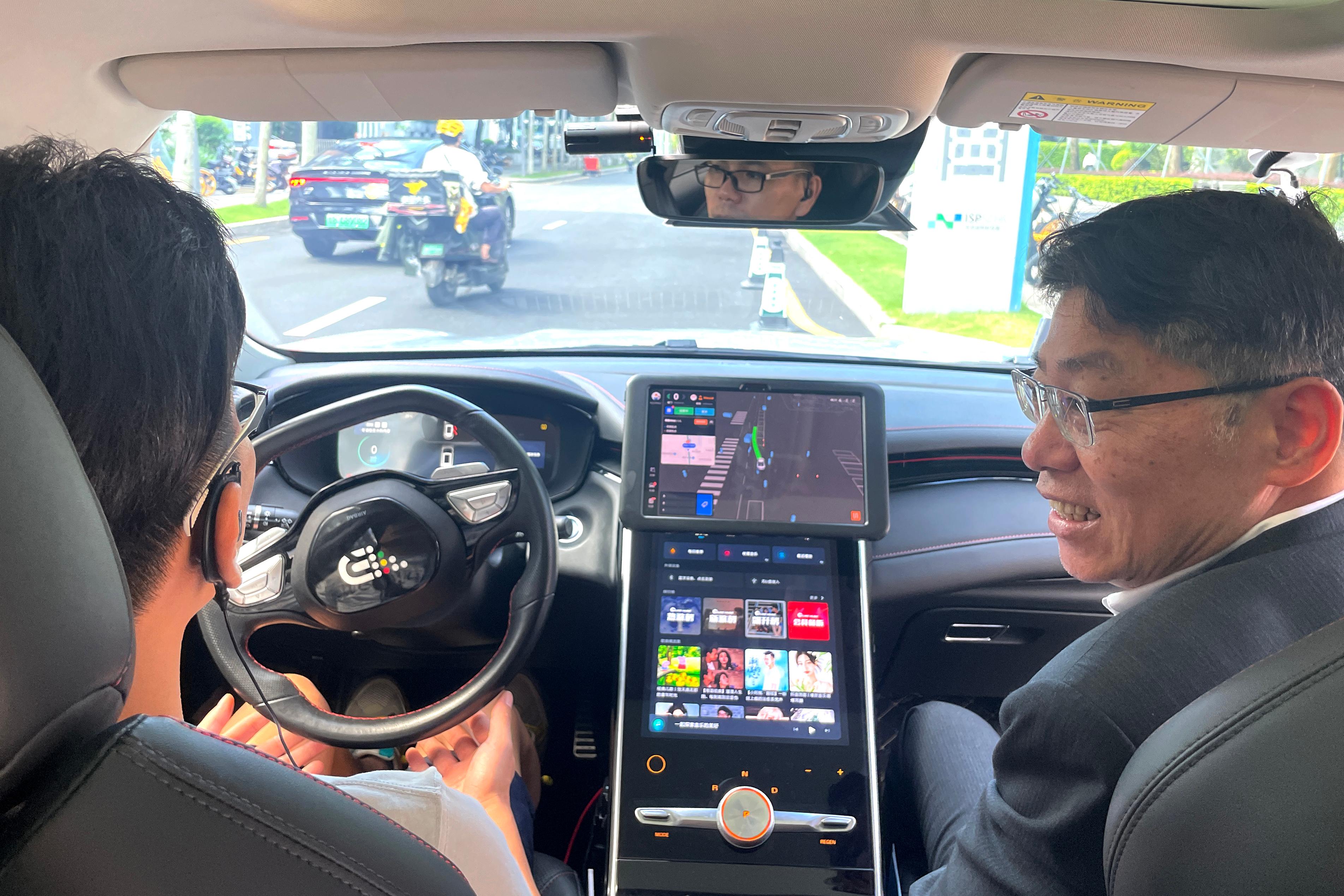 The Secretary for Transport and Logistics, Mr Lam Sai-hung (right), today (July 20) took a test ride in an autonomous vehicle (AV) in Futian to gain a better understanding of the operation and development of AVs in Shenzhen. The person sitting next to him is a safety operator.