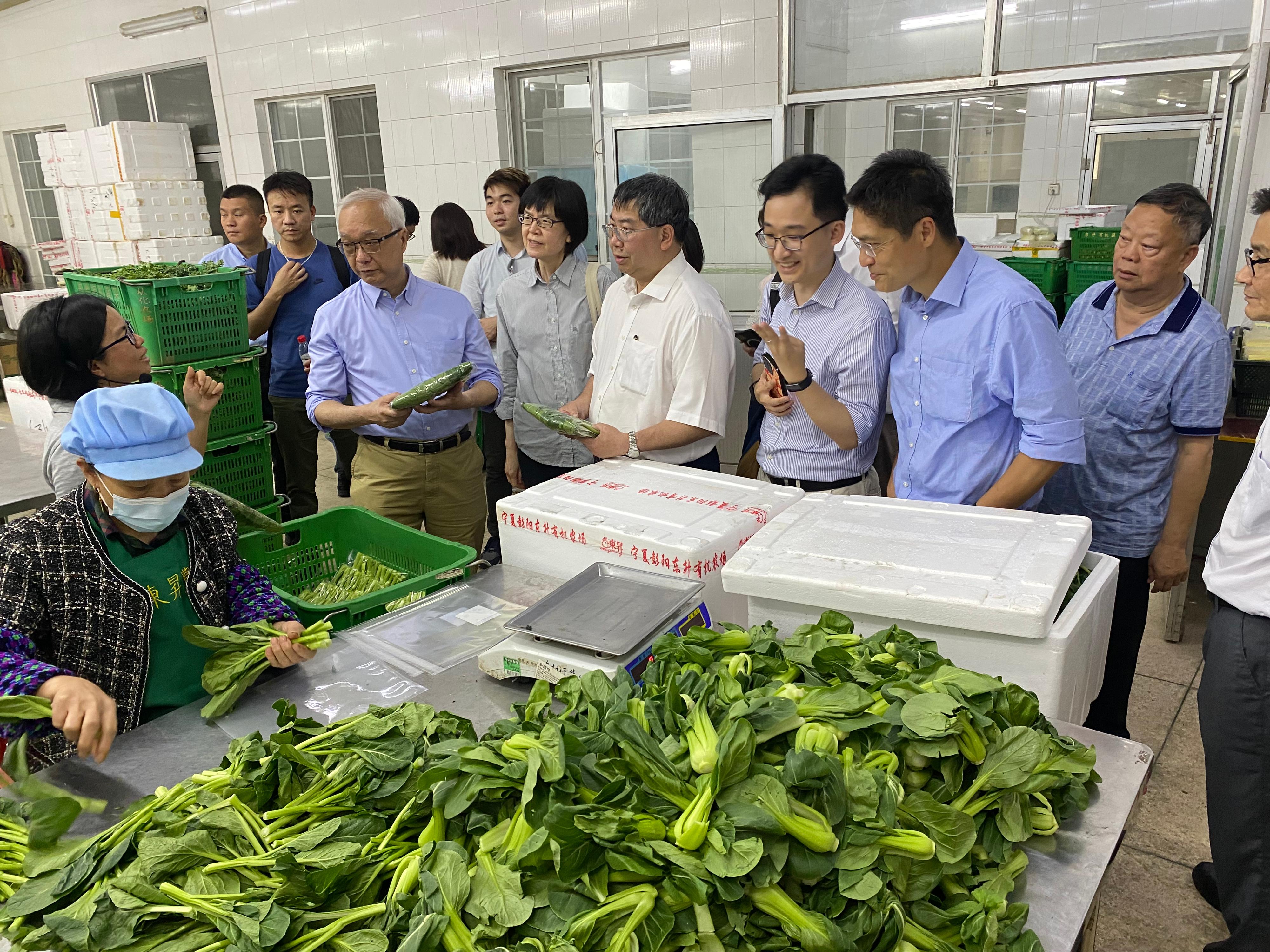 The Secretary for Environment and Ecology, Mr Tse Chin-wan, visited a vegetable farm in Nansha District of Guangzhou yesterday morning (July 19). Photo shows Mr Tse (third left); the Permanent Secretary for Environment and Ecology (Food), Miss Vivian Lau (fourth left); and the Director of Agriculture, Fisheries and Conservation, Dr Leung Siu-fai (fifth left), receiving a briefing from a representative on their advanced facilities and agricultural product safety tracking system.