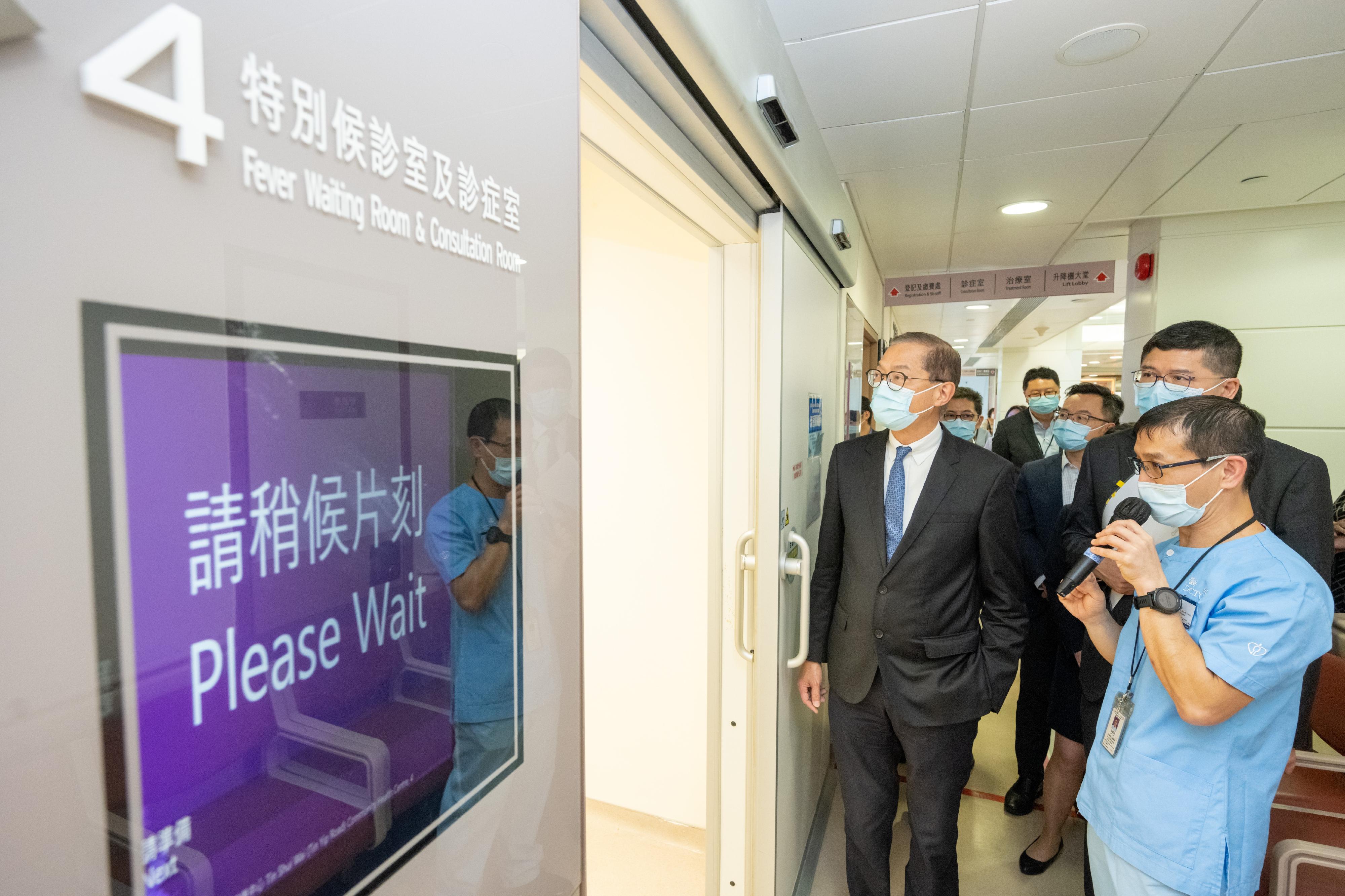 The Secretary for Health, Professor Lo Chung-mau (left), visits the Tin Shui Wai (Tin Yip Road) Community Health Centre today (July 20) and tours the general out-patient fever waiting room and consultation room, while receiving a briefing by a healthcare staff member on the relevant services.