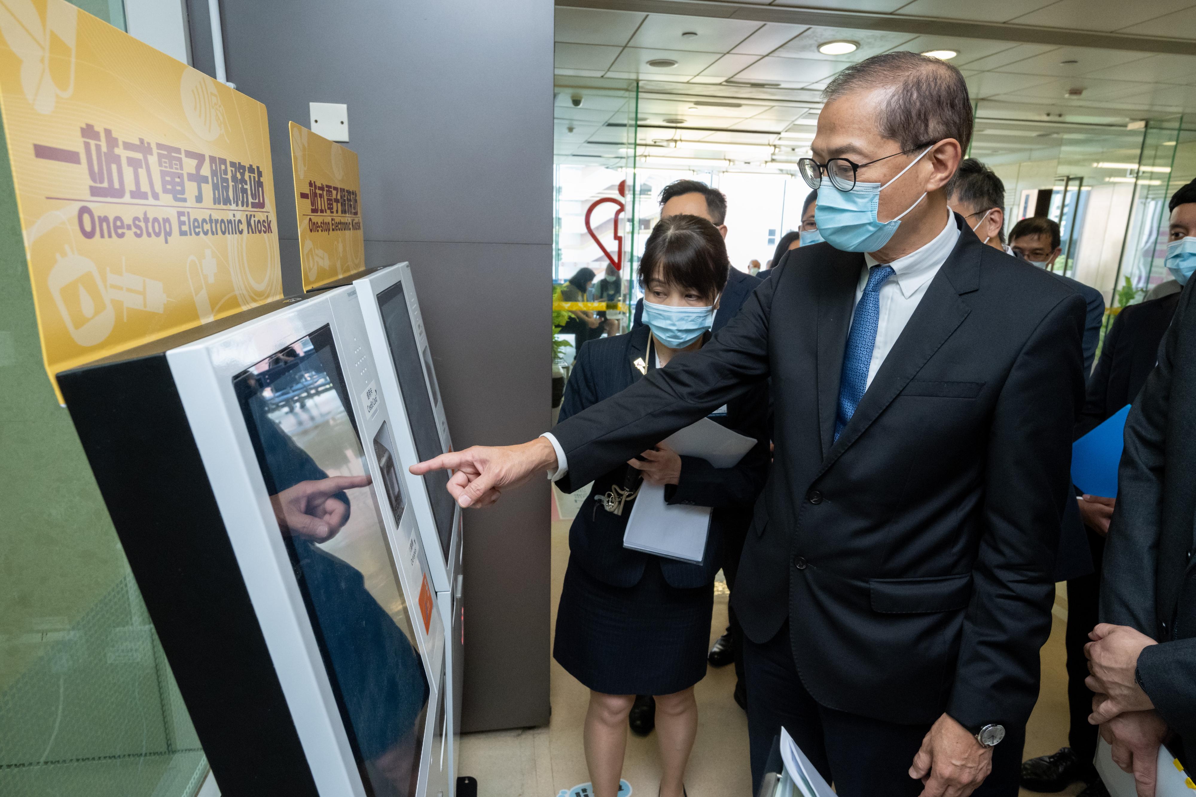 The Secretary for Health, Professor Lo Chung-mau (right), visits the Tin Shui Wai (Tin Yip Road) Community Health Centre today (July 20) to learn more about the function of the one-stop electronic kiosk.