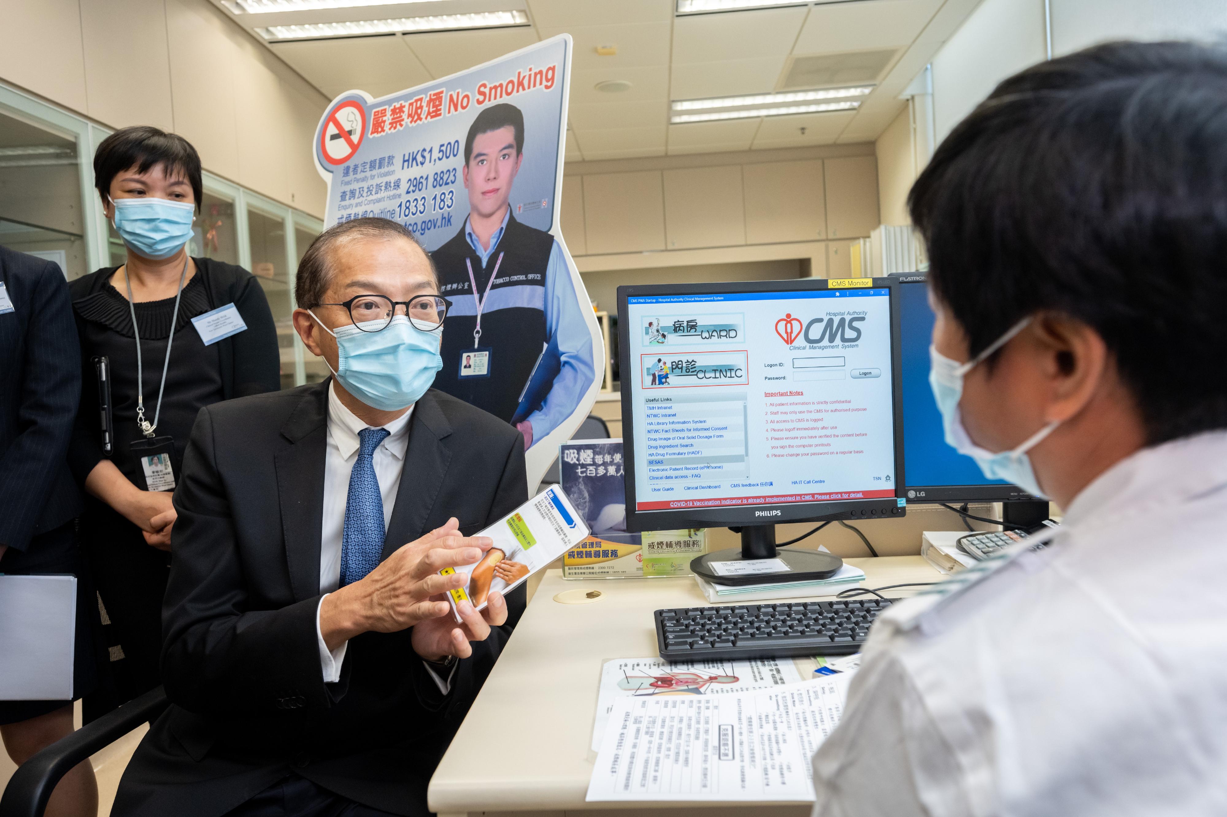 The Secretary for Health, Professor Lo Chung-mau (second left), visits the Tin Shui Wai (Tin Yip Road) Community Health Centre today (July 20) and receives a briefing by a staff member on the smoking cessation service provided by the Centre.