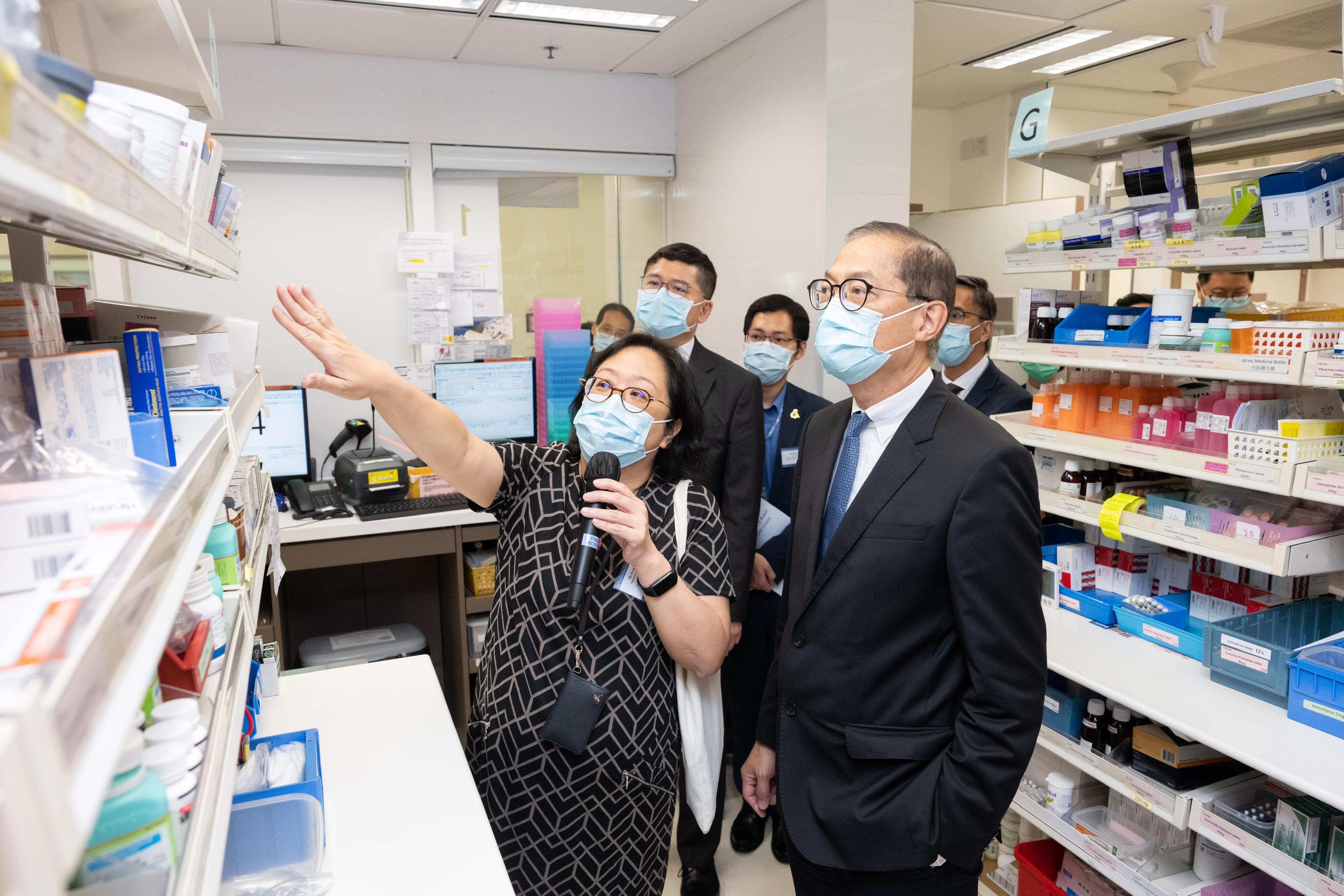 The Secretary for Health, Professor Lo Chung-mau (right), visits the Tin Shui Wai (Tin Yip Road) Community Health Centre today (July 20) and tours the pharmacy of the Centre to get a better understanding of the pharmaceutical services available at the Centre.