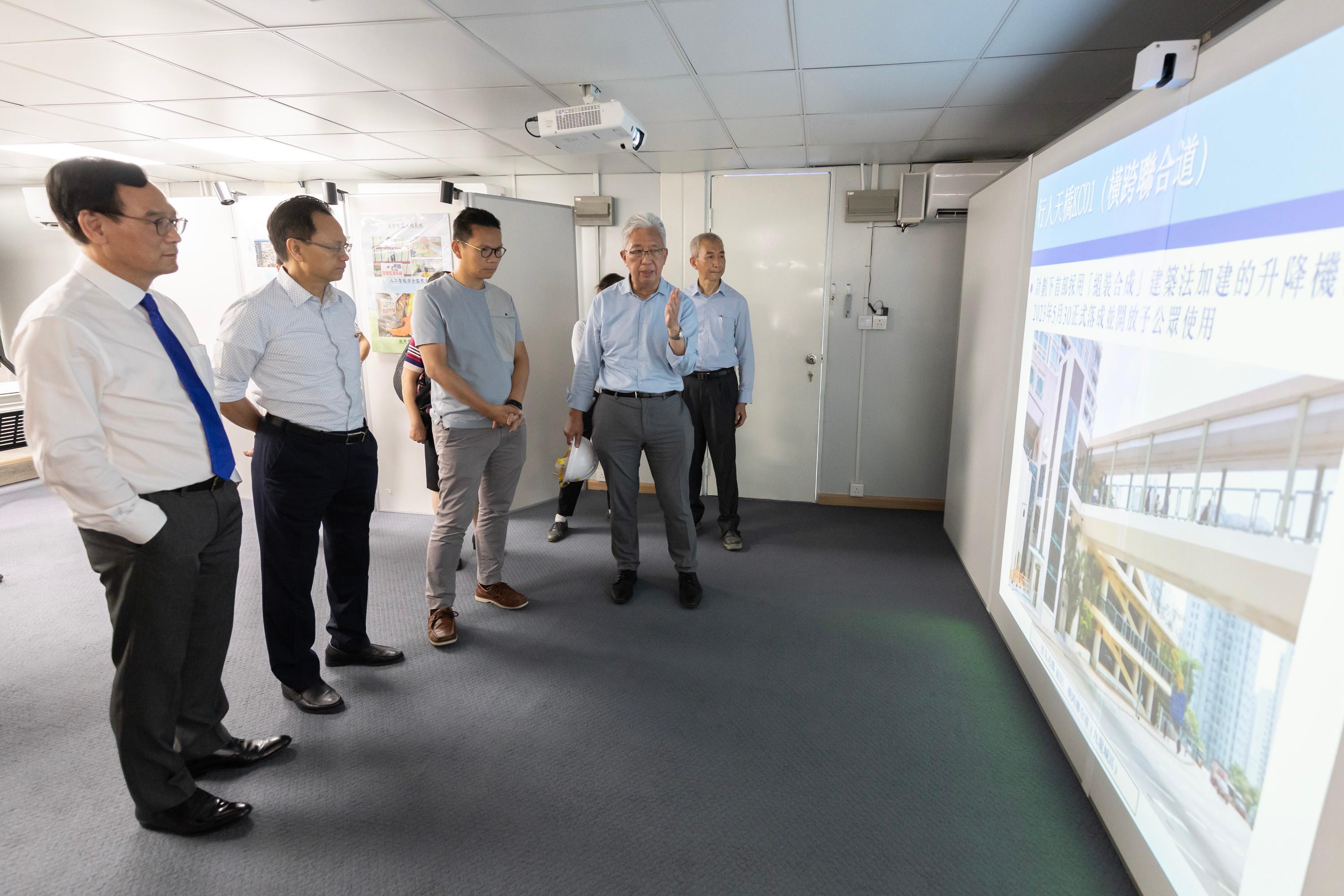 The Legislative Council Panel on Transport visited the Modular Integrated Construction lift assembly yard under the Universal Accessibility Programme (UA Programme) today (July 21) to learn about the Government's latest progress in building barrier-free facilities in public walkways. Photo shows Members receiving a briefing from representatives of the Highways Department on the UA Programme.
