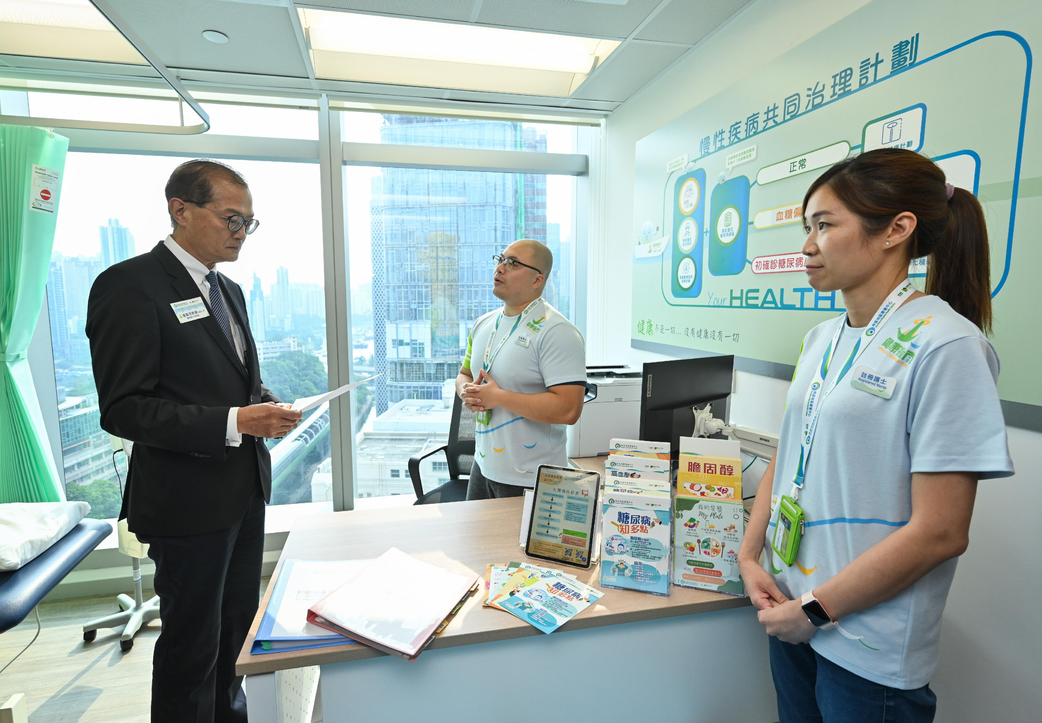 醫務衞生局局長盧寵茂教授（左）今日（七月二十六日）下午聽取南區地區康健中心的護士介紹中心將如何全力配合政府今年第四季推出的「慢性疾病共同治理先導計劃」。
