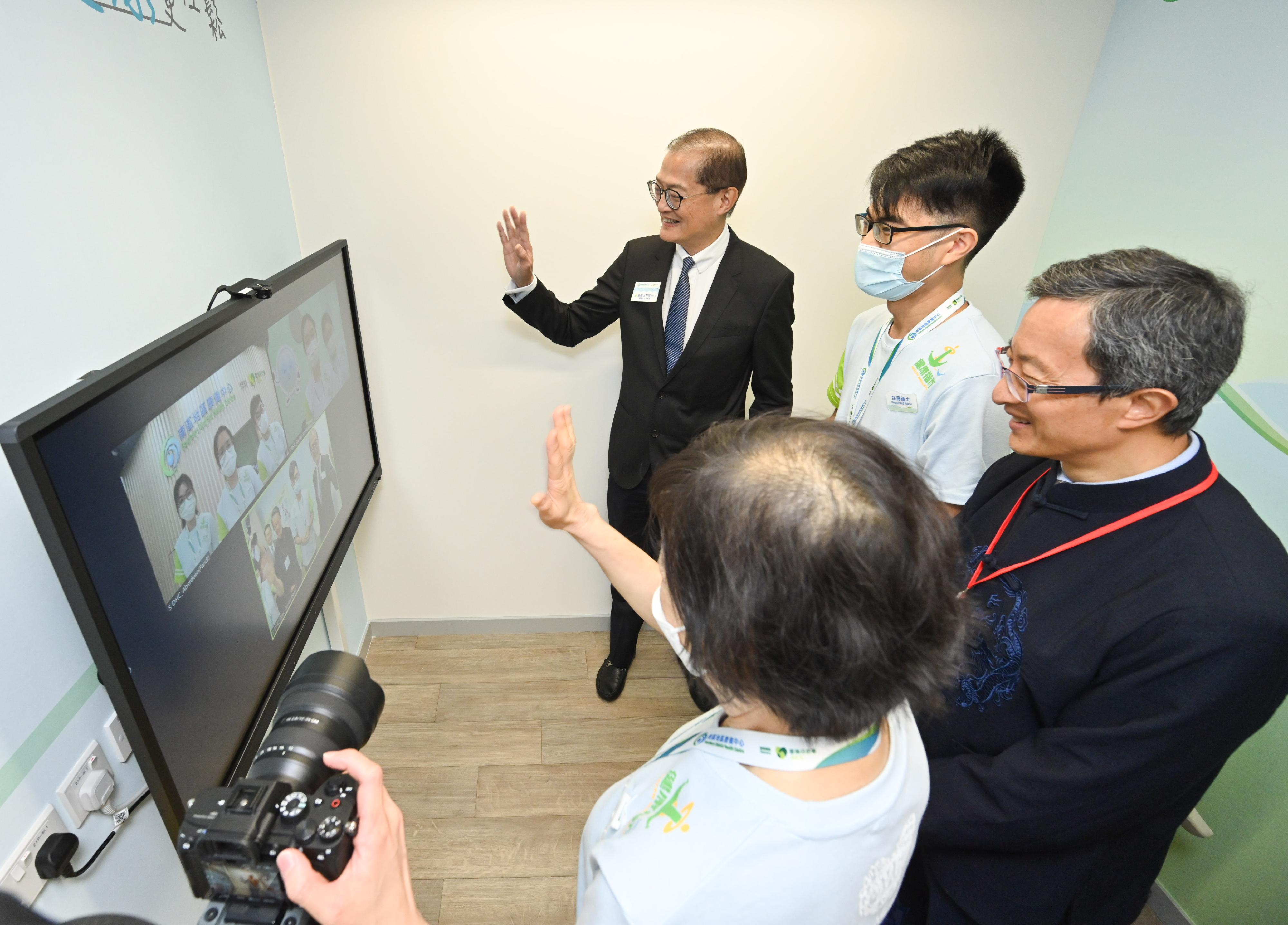 The Secretary for Health, Professor Lo Chung-mau (left), gains a better understanding on how the Southern District Health Centre (DHC) utilises its telemedicine services to serve more DHC members with prompt and appropriate medical assistance through a demonstration by staff members this afternoon (July 26).