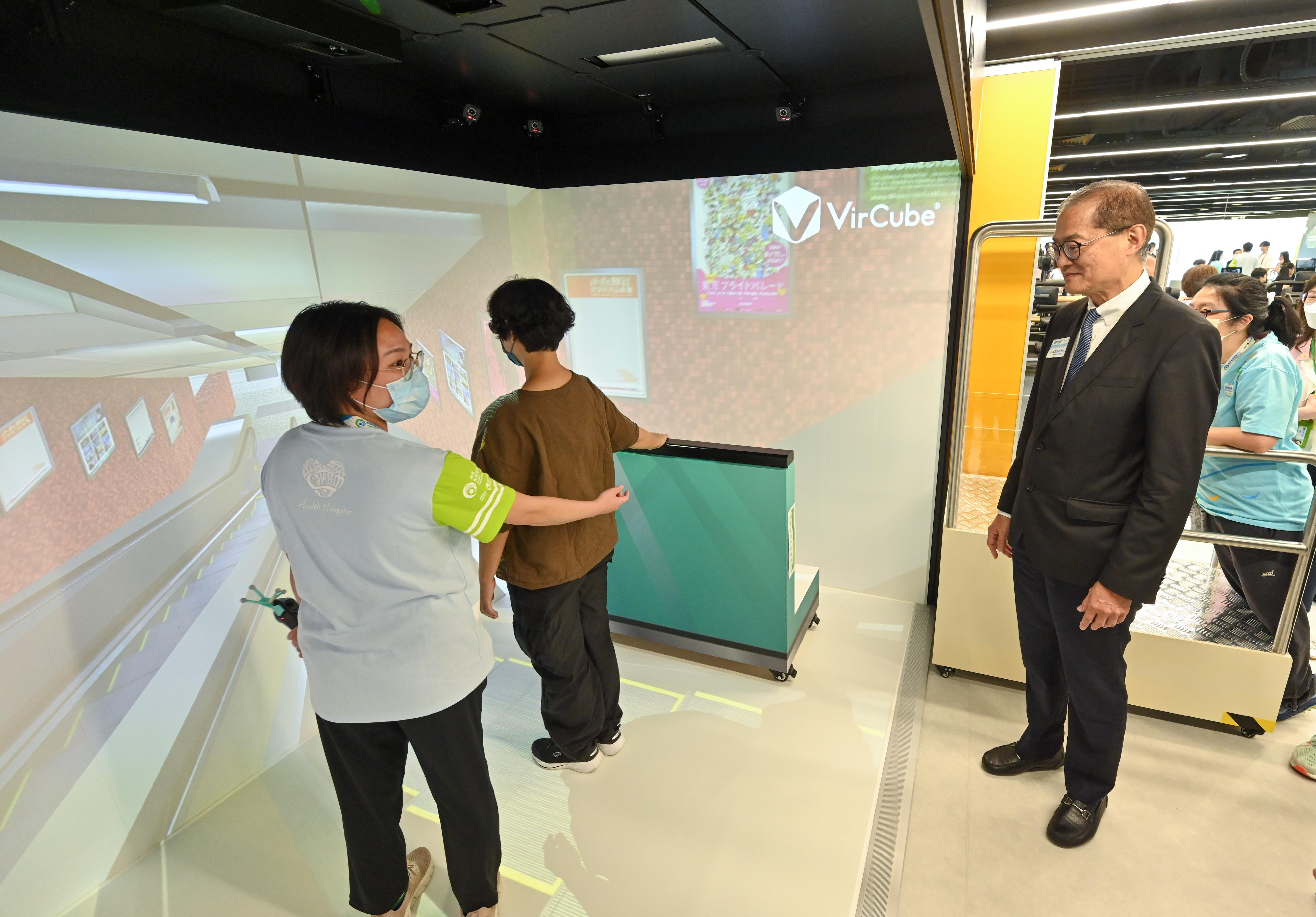 While inspecting the Southern District Health Centre (DHC) this afternoon (July 26), the Secretary for Health, Professor Lo Chung-mau (first right), learns from the staff about how the centre utilises a virtual reality fitness training system specifically set up to assist DHC members to train their life skills through rehabilitation exercises.