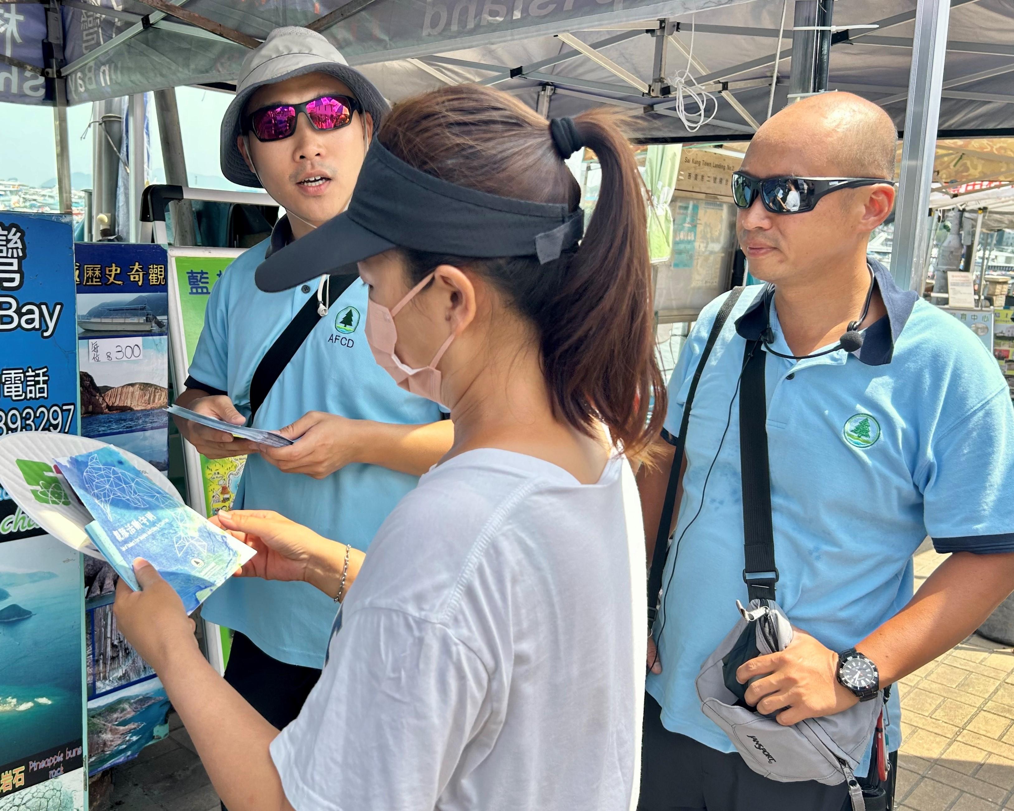 就近日西貢水域有鯨魚出現，漁農自然護理署（漁護署）今日（七月二十六日）強烈勸喻市民不要追蹤鯨魚。圖示漁護署人員派發宣傳單張，提醒市民發現鯨魚出沒時的注意事項。