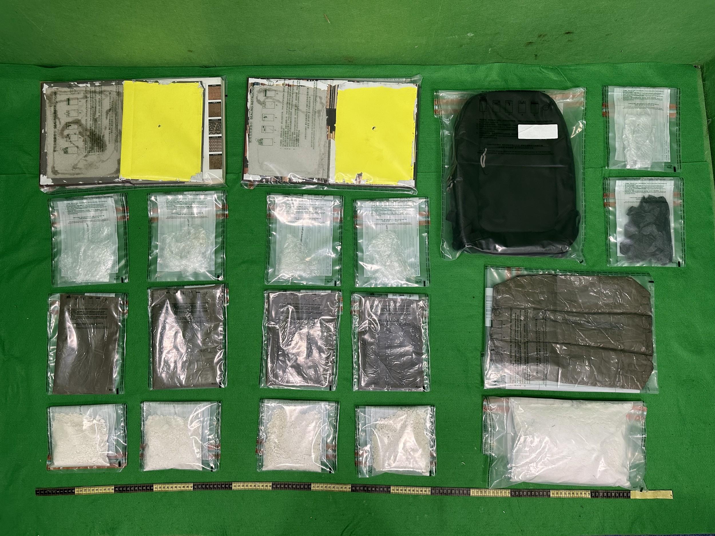 香港海關昨日（七月三十日）在香港國際機場檢獲約兩公斤懷疑可卡因，估計市值約二百二十萬元。圖示檢獲的懷疑可卡因及用作收藏毒品的書本和背囊。