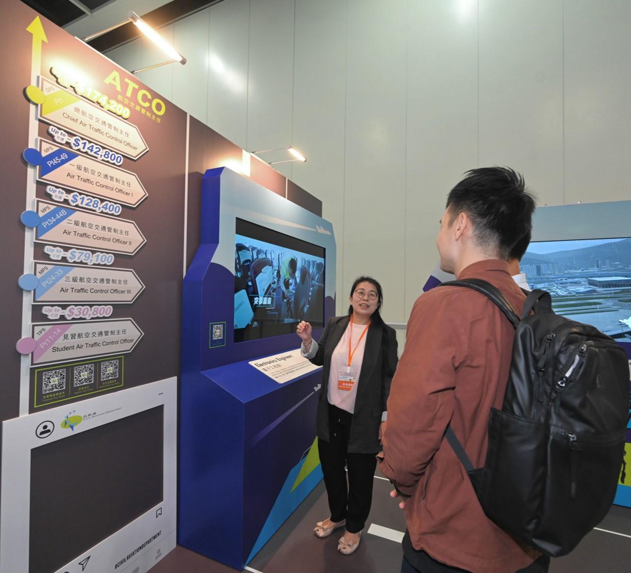 The Civil Aviation Department (CAD) participates in the Hong Kong International Airport Career Expo 2023 for three consecutive days from today (August 4) to August 6 (Sunday) at the Hong Kong Convention and Exhibition Centre in Wan Chai. Photo shows a CAD staff member introducing job duties and career information of various professional grades of the CAD.