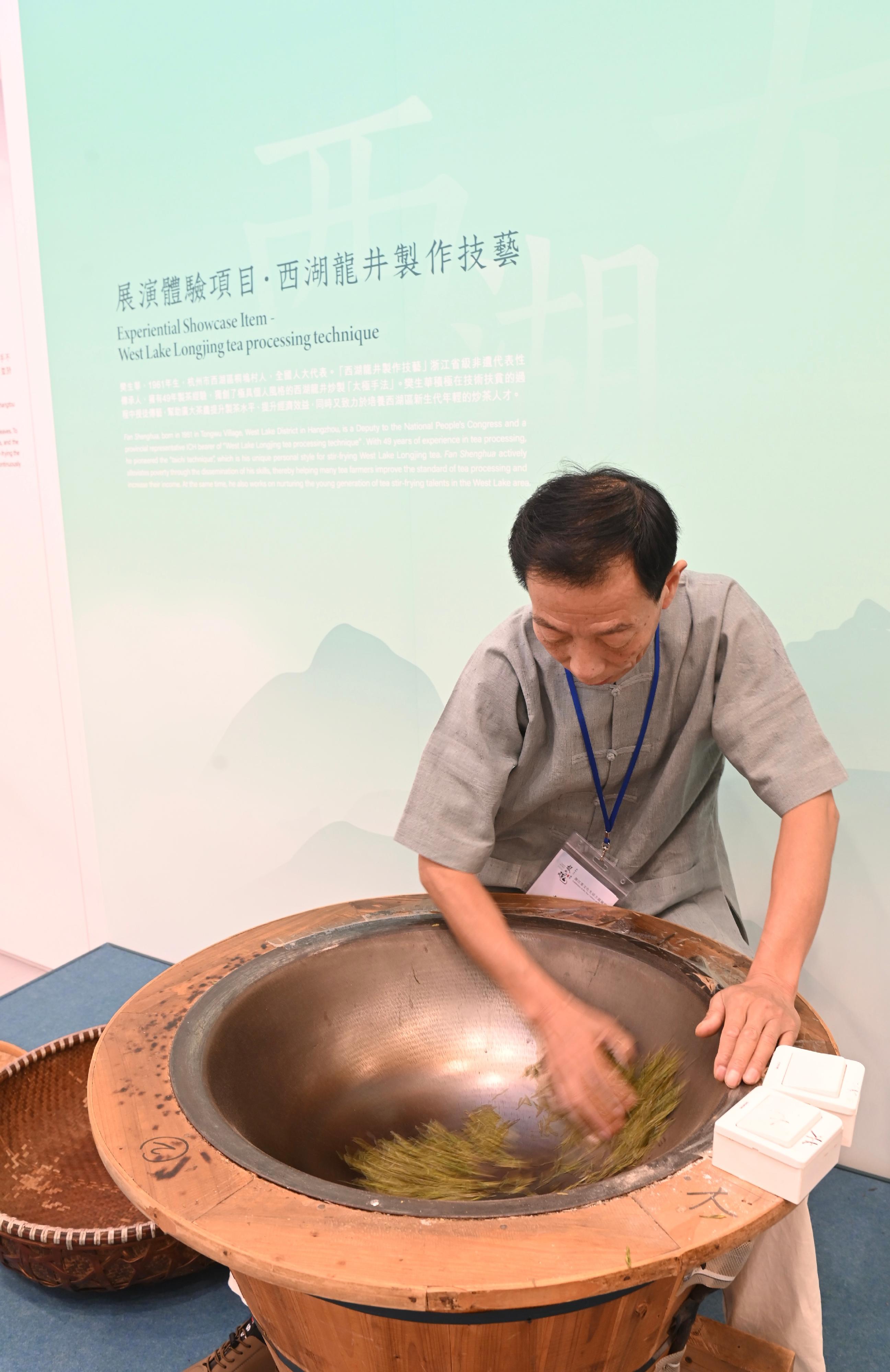 The opening ceremony for the "Genesis and Spirit - Tea for Harmony · Yaji Cultural Salon: Exhibition of the Tea Culture of Zhejiang" was held today (August 4) at the Hong Kong Central Library. Photo shows the demonstration of world intangible cultural heritage item, West Lake Longjing tea processing technique.