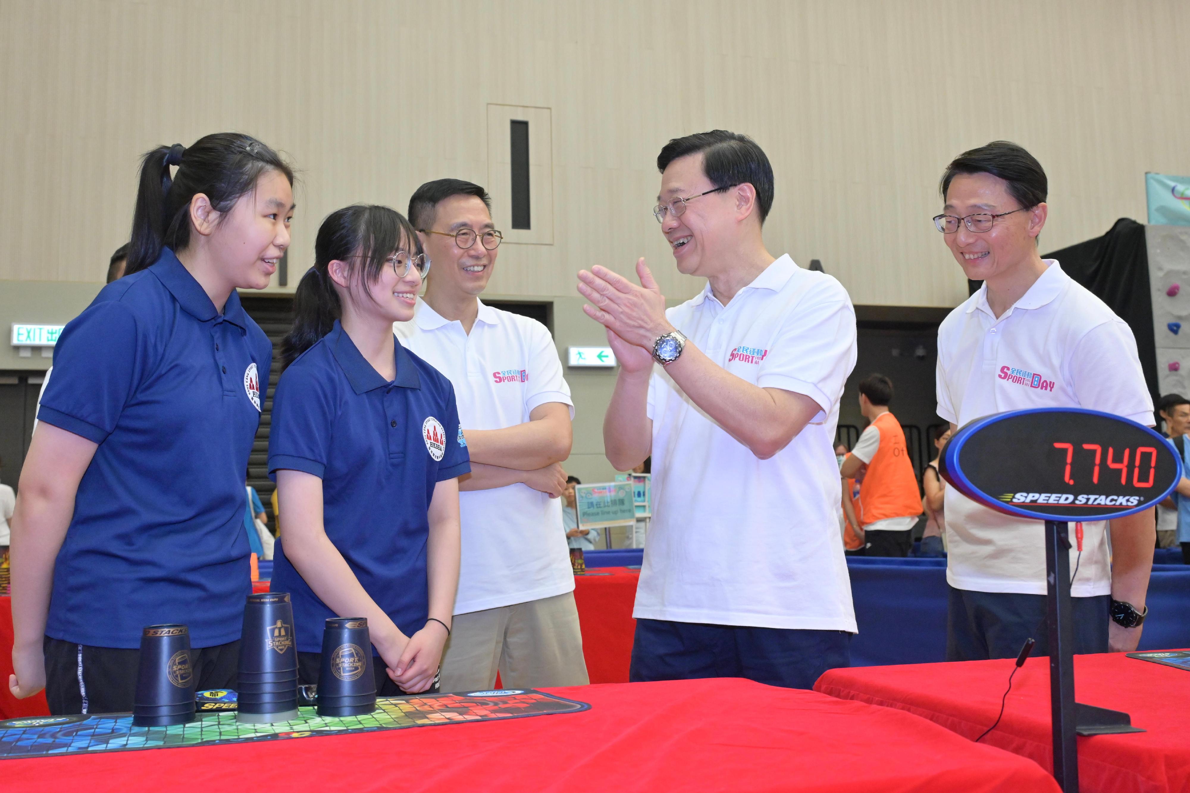 The Chief Executive, Mr John Lee, attended the Sport For All Day 2023 held by the Leisure and Cultural Services Department at the Sham Shui Po Sports Centre and took part in sports fun games this afternoon (August 6). Photo shows Mr Lee (second right) chatting with speed stacks athletes.
