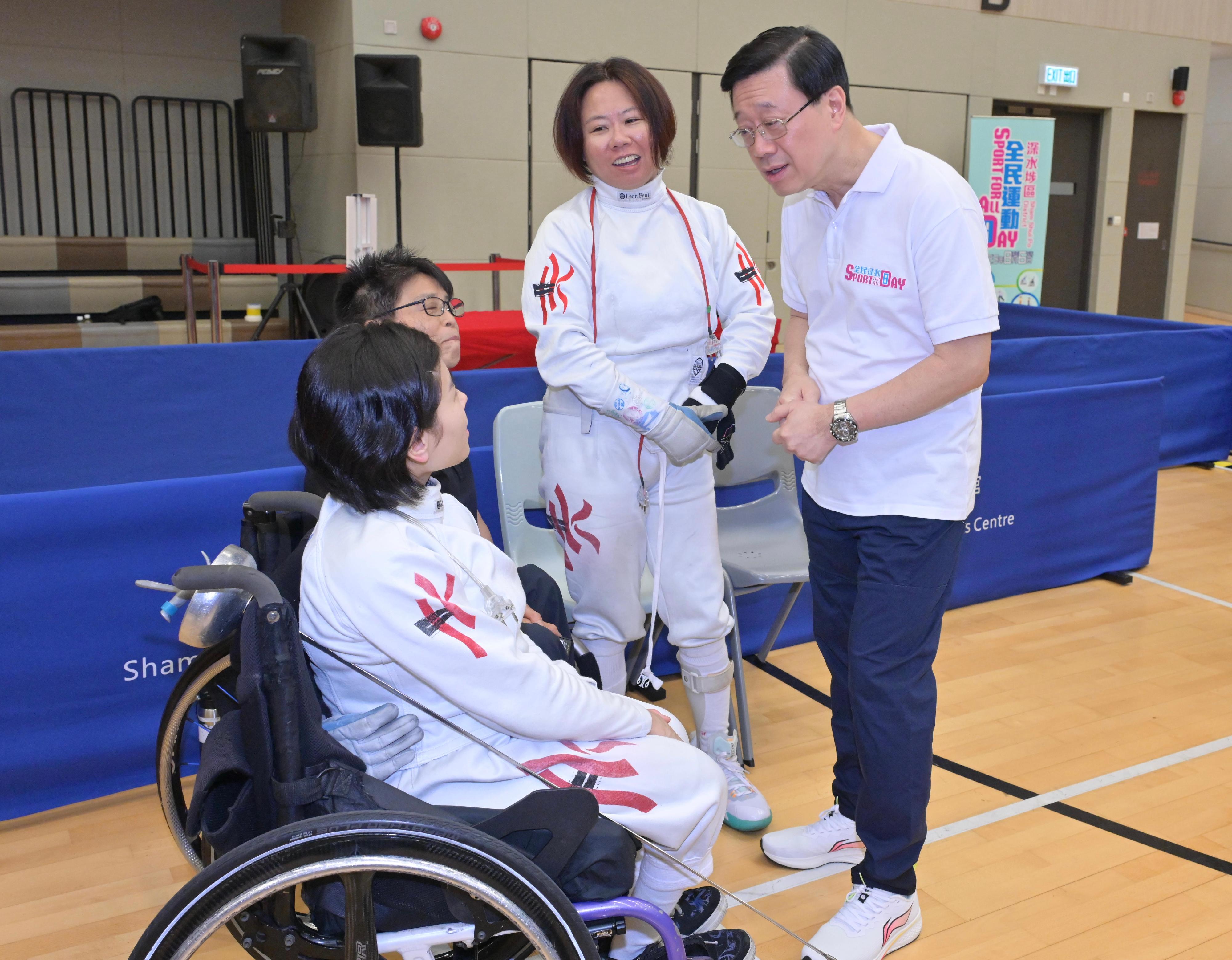 The Chief Executive, Mr John Lee, attended the Sport For All Day 2023 held by the Leisure and Cultural Services Department at the Sham Shui Po Sports Centre and took part in sports fun games this afternoon (August 6). Photo shows Mr Lee (first right) chatting with fencing athletes.
