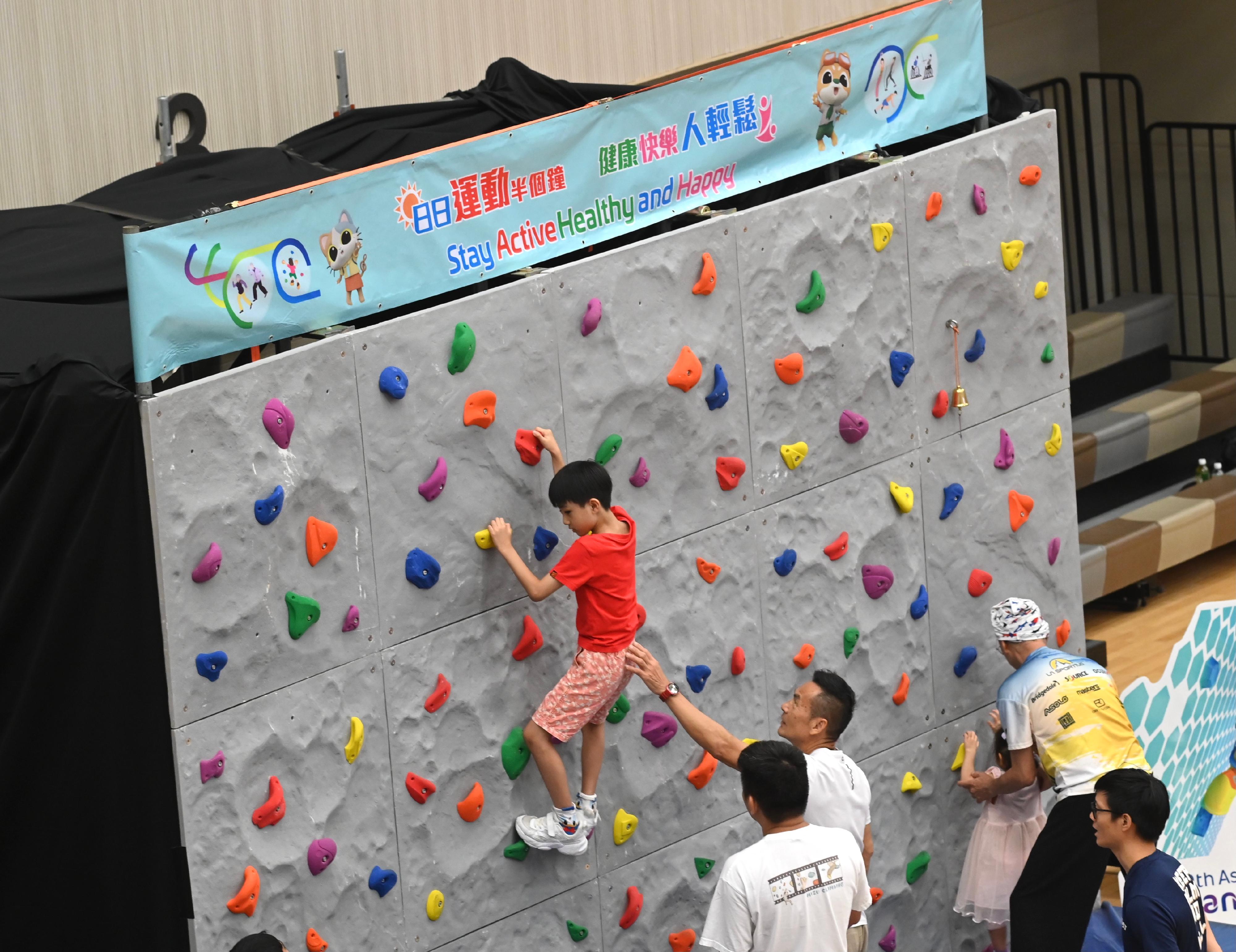 The Sport For All Day 2023 was held by the Leisure and Cultural Services Department today (August 6) with free recreation and sports programmes at designated sports centres in 18 districts for the public to join. Photo shows a member of the public taking part in sports climbing play-in session.

