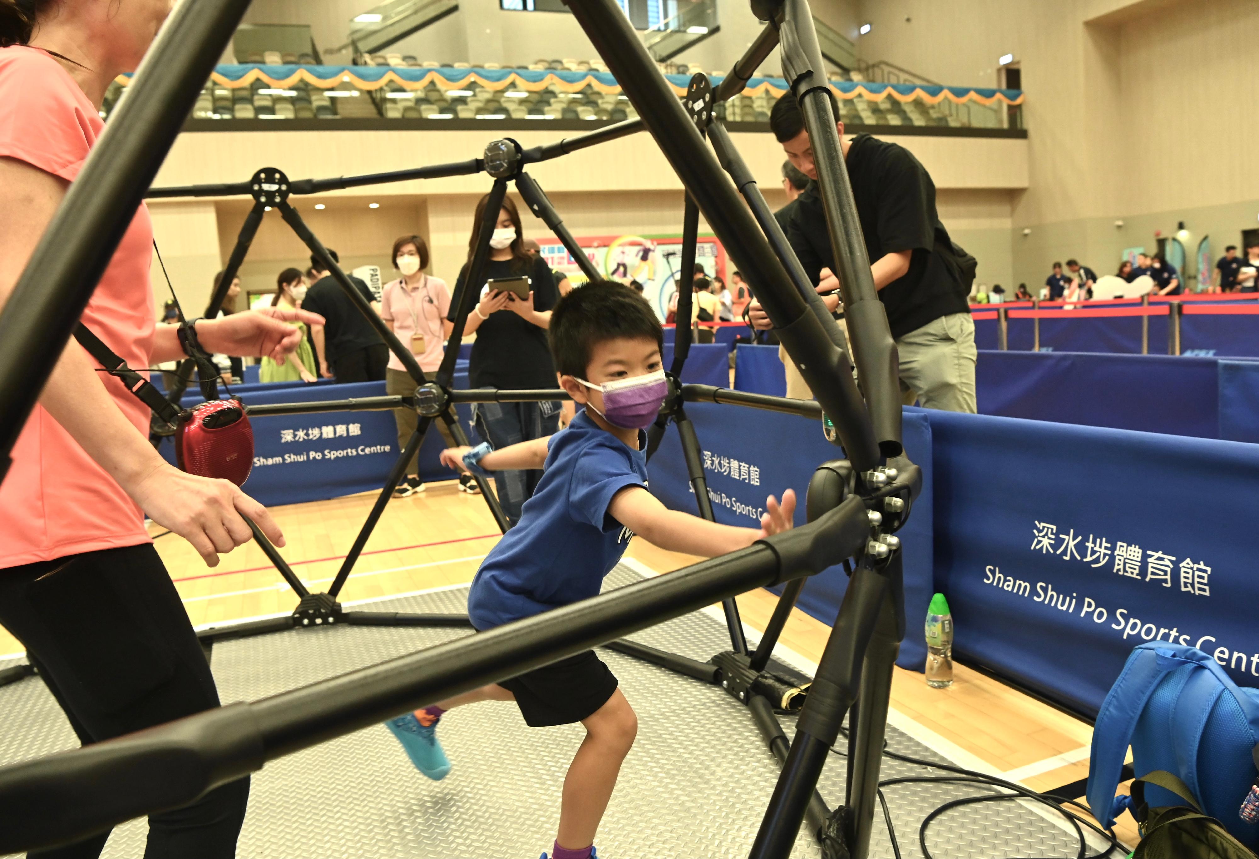 The Sport For All Day 2023 was held by the Leisure and Cultural Services Department today (August 6) with free recreation and sports programmes at designated sports centres in 18 districts for the public to join. Photo shows a member of the public taking part in electronic cardio cage play-in session.
