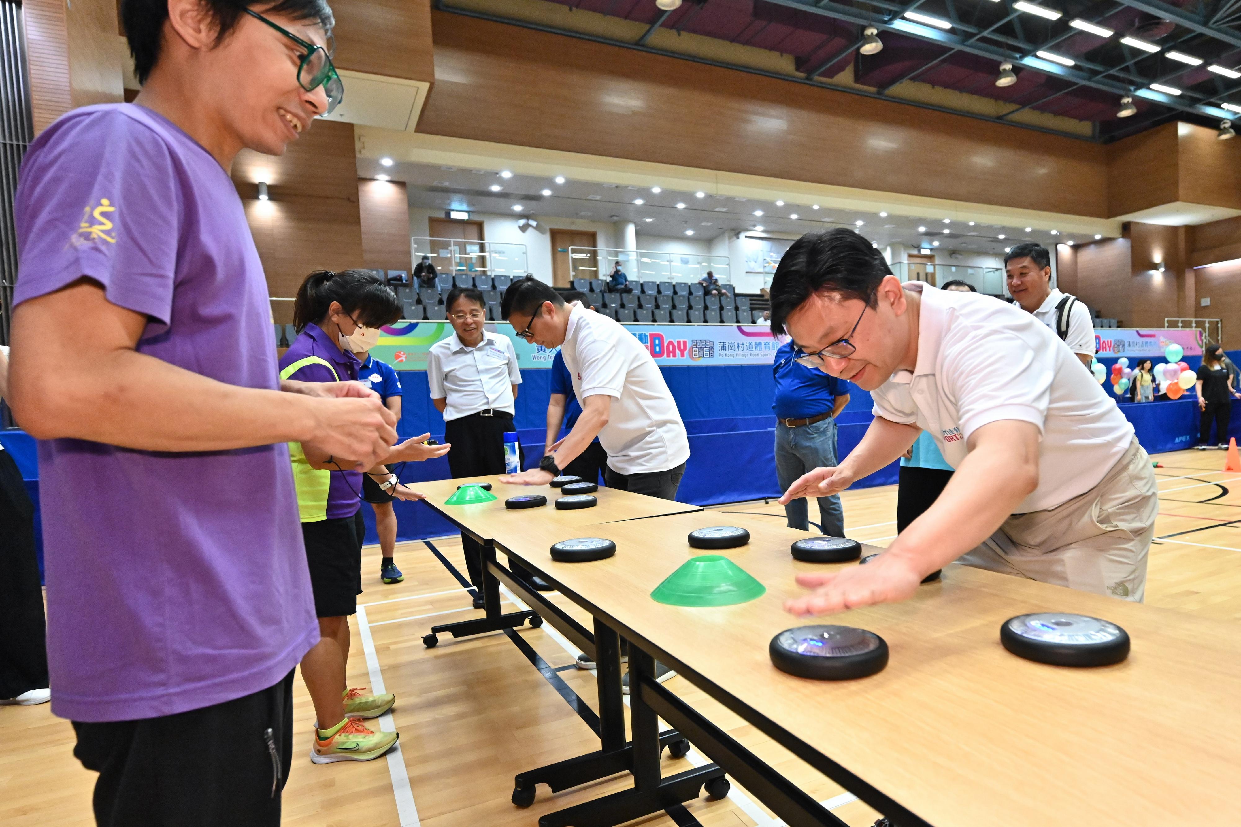 The Secretary for Security, Mr Tang Ping-keung, and the Secretary for Labour and Welfare, Mr Chris Sun, joined the public for sports and recreation programmes at Po Kong Village Road Sports Centre this afternoon (August 6) as part of the Sport For All Day 2023 organised by the Leisure and Cultural Services Department. Photo shows Mr Tang (second right) and Mr Sun (first right) in a fitness game testing the body's agility.