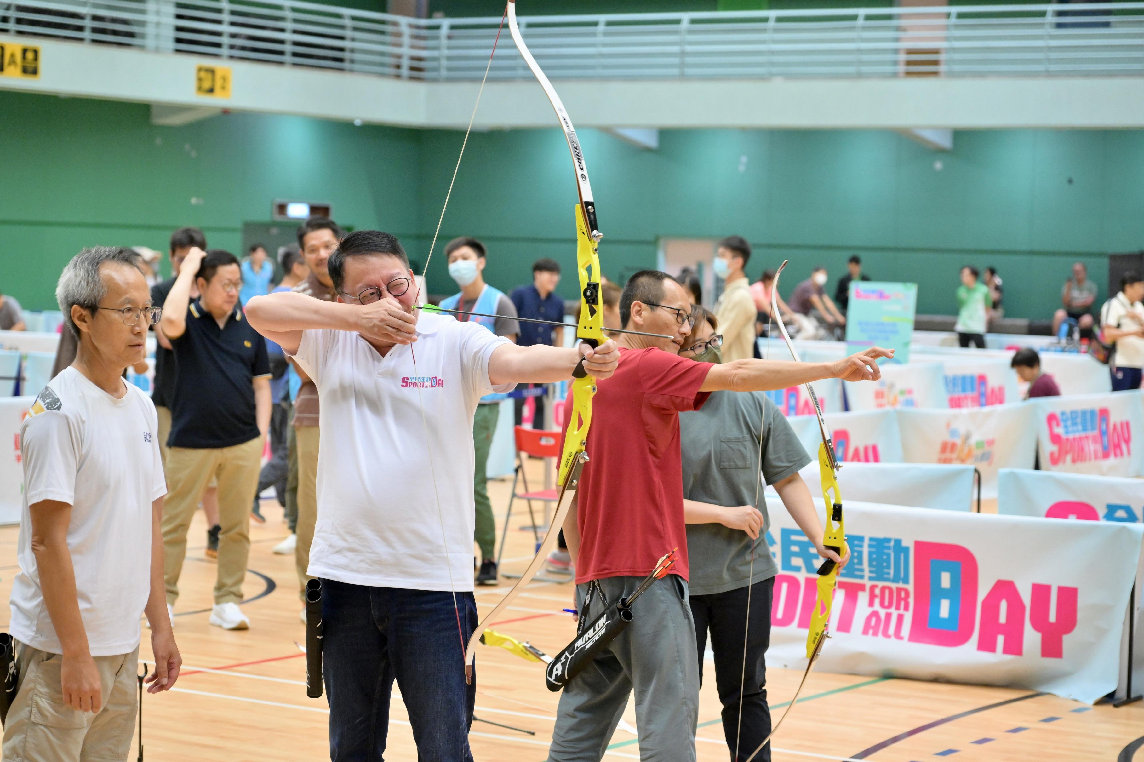 The Chief Secretary for Administration, Mr Chan Kwok-ki, participated in the Sport For All Day 2023 activities organised by the Leisure and Cultural Services Department at Yuen Wo Road Sports Centre in Sha Tin today (August 6). Photo shows Mr Chan (second left) joining an archery session with the public.