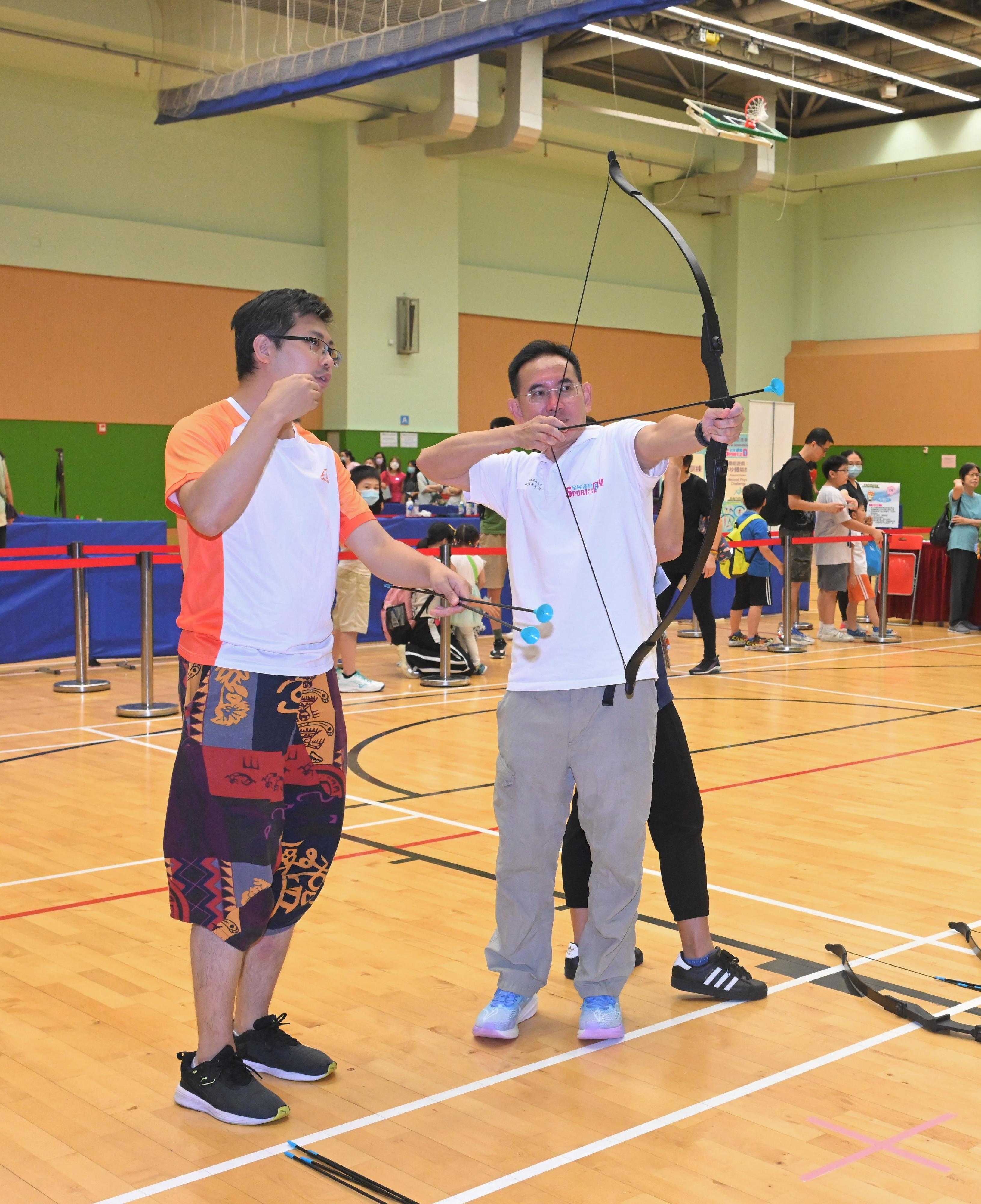 The Acting Secretary for Development, Mr David Lam, participated in the Sport For All Day 2023 activities organised by the Leisure and Cultural Services Department at Island East Sports Centre today (August 6). Photo shows Mr Lam (right) joining an archery session.