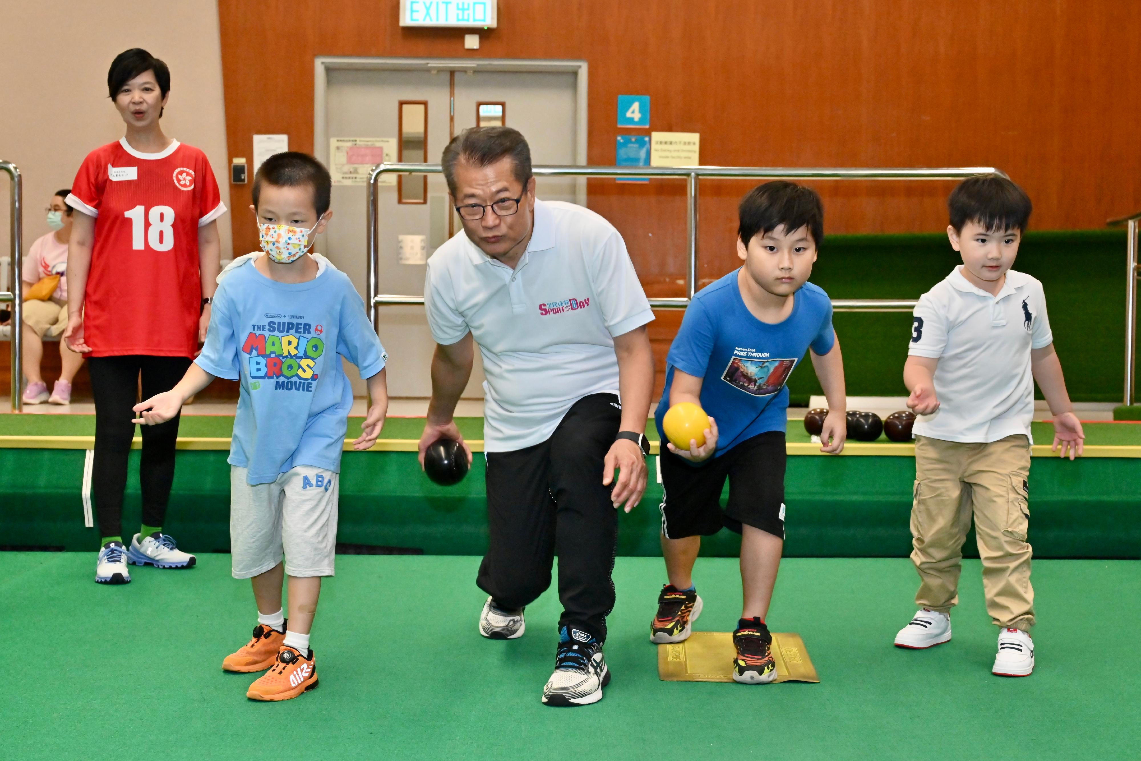 The Financial Secretary, Mr Paul Chan, participated in the Sport For All Day 2023 organised by the Leisure and Cultural Services Department at Island East Sports Centre today (August 6). Photo shows Mr Chan (centre) joining an indoor bowling play-in session with children. Looking on is the Secretary for Housing, Ms Winnie Ho (first left).
