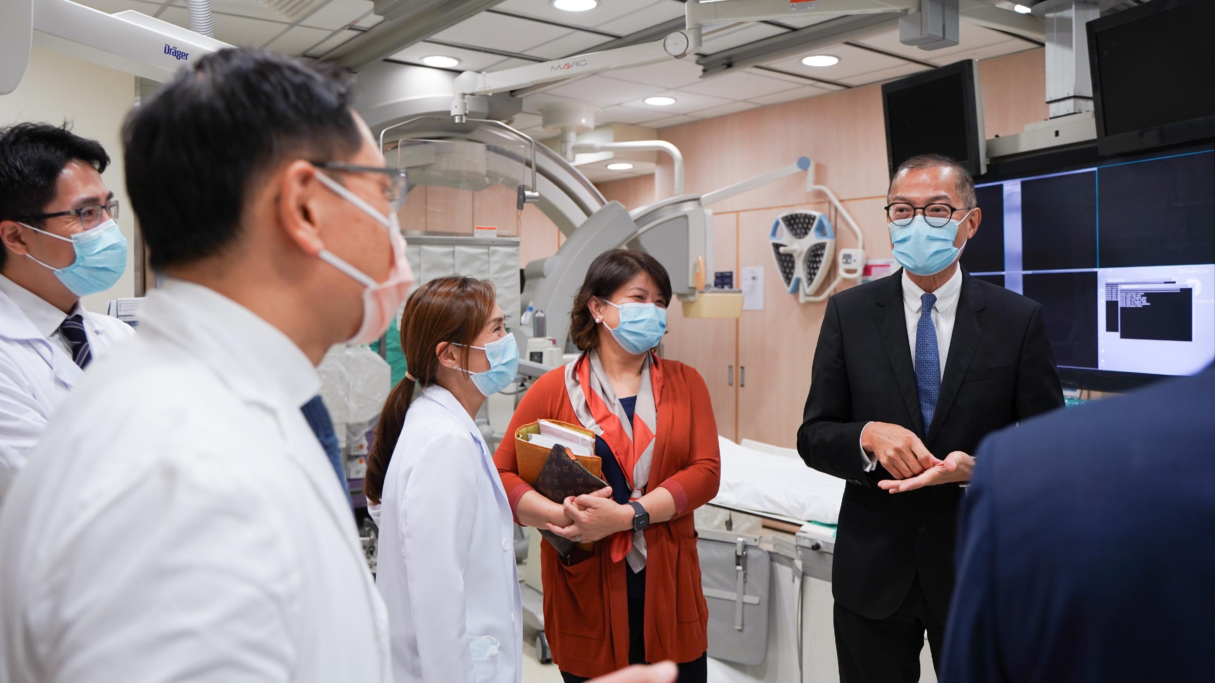 The Secretary for Health, Professor Lo Chung-mau, visited the Queen Mary Hospital today (August 8). Photo shows Professor Lo (first right) and the Under Secretary for Health, Dr Libby Lee (second right); visiting the Cardiac Catheterization Laboratory of the hospital with the Cluster Chief Executive of Hong Kong West Cluster of the Hospital Authority, Dr Theresa Li (third right).