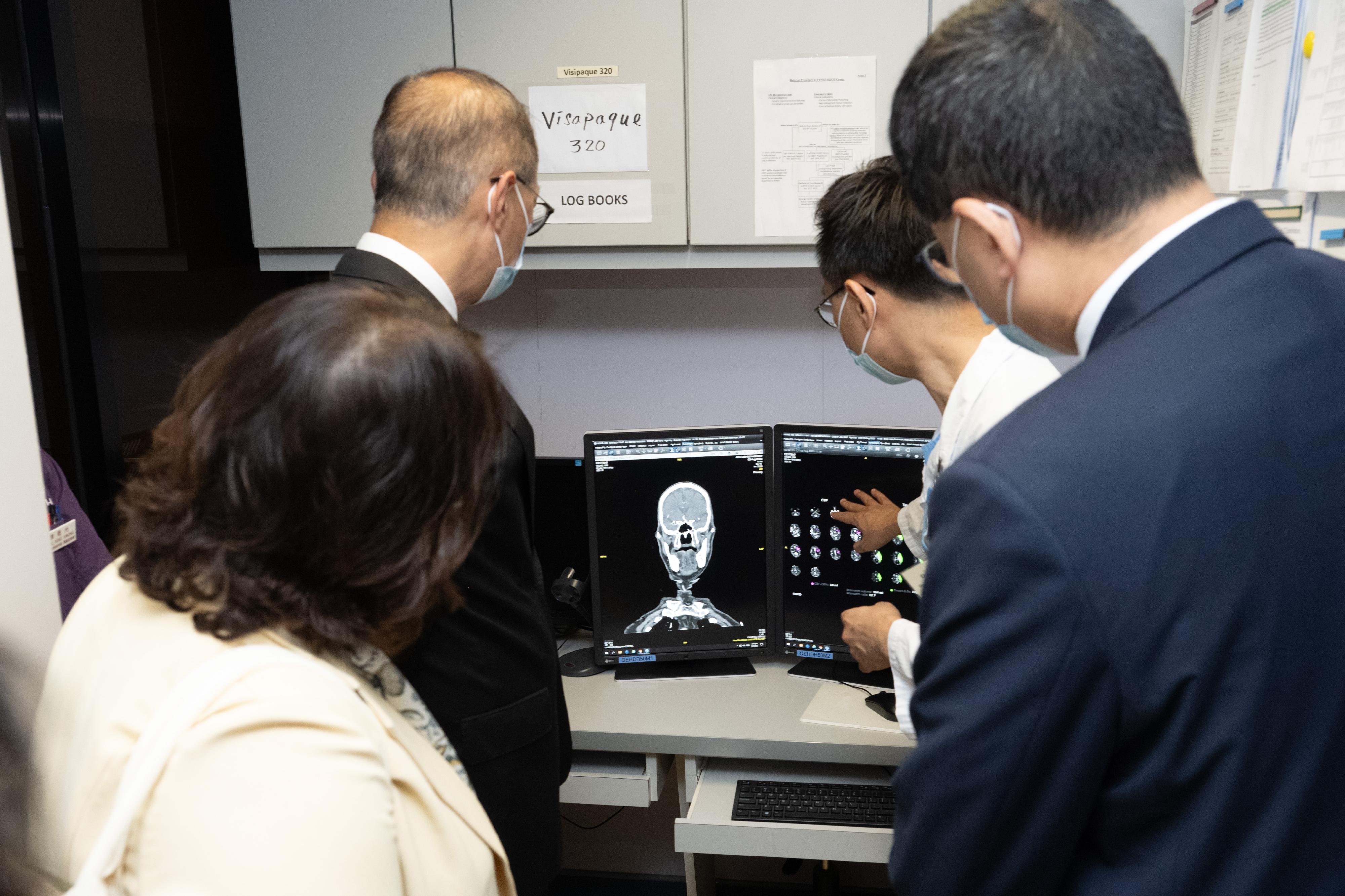 The Secretary for Health, Professor Lo Chung-mau (back row, left), today (August 9) visits Queen Elizabeth Hospital and learns about the diagnosis and treatment processes for patients suffering from complicated neurological diseases.