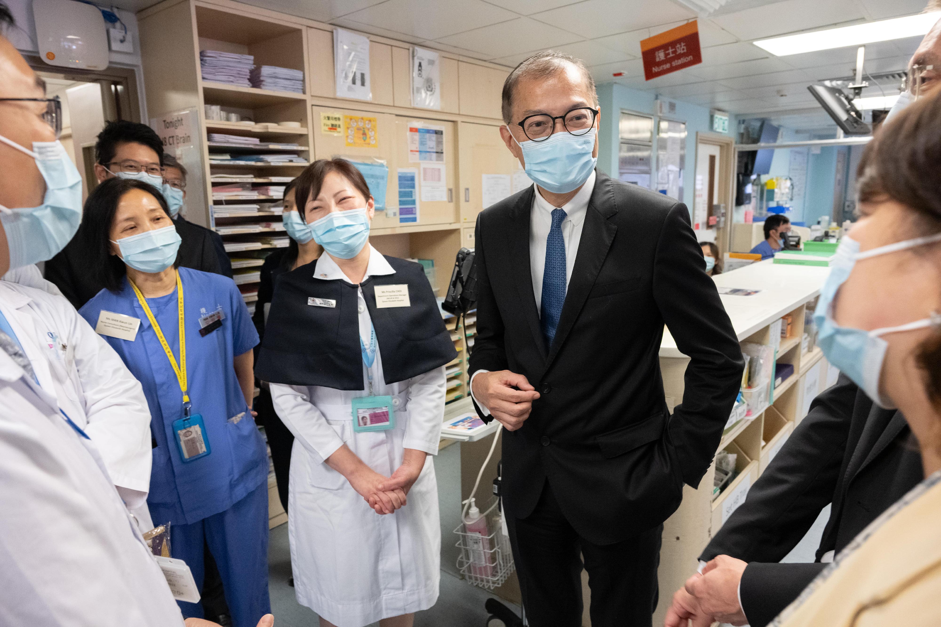 The Secretary for Health, Professor Lo Chung-mau (right), visits the Neurosurgical Special Care Ward of Queen Elizabeth Hospital and chats with healthcare staff today (August 9).