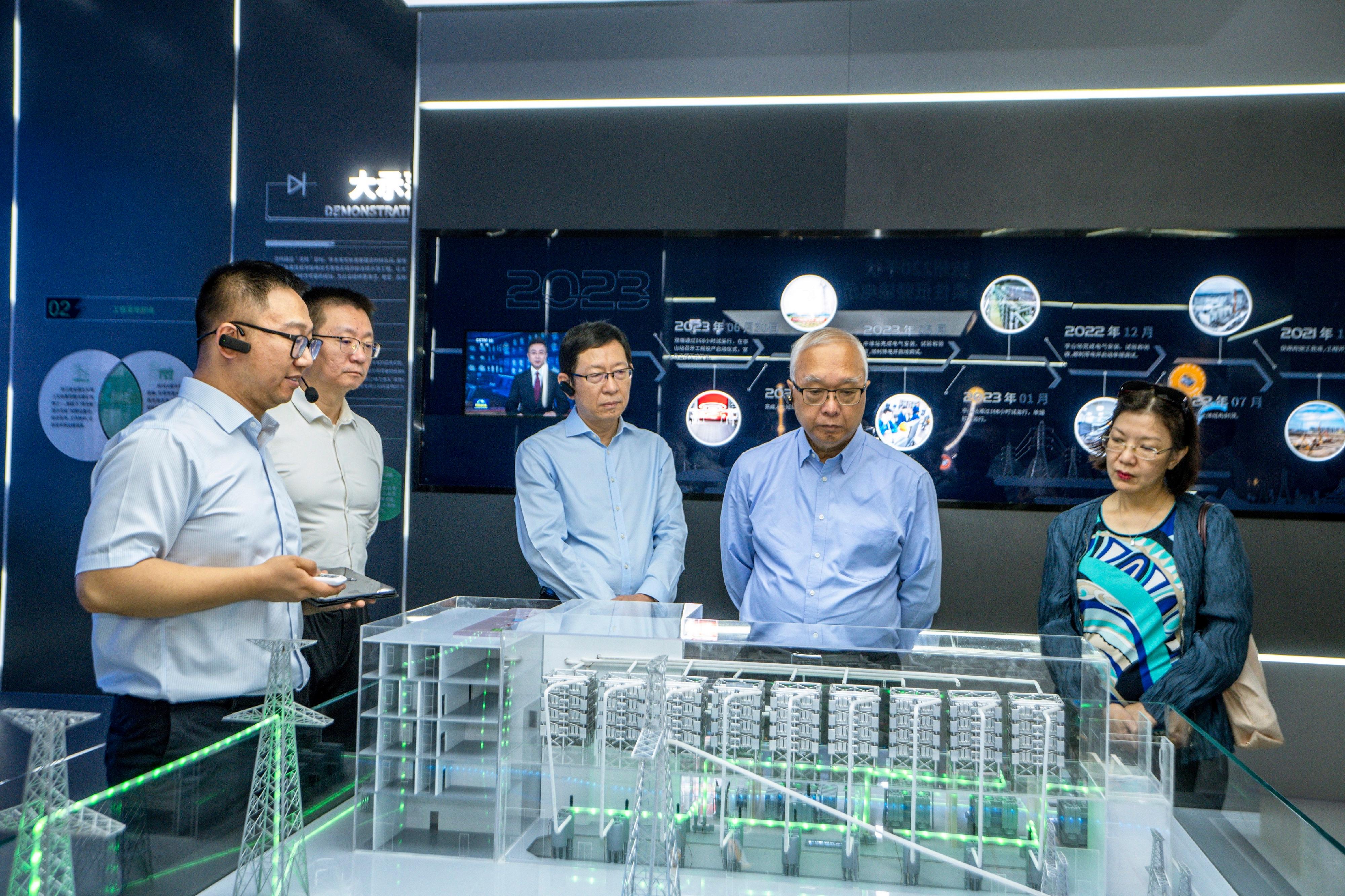 The Secretary for Environment and Ecology, Mr Tse Chin-wan, today (August 11) visited the flexible low-frequency transmission pilot project in Hangzhou. Photo shows Mr Tse (second right), and the Permanent Secretary for Environment and Ecology (Environment), Miss Janice Tse (first right), receiving a briefing from the representative on the development of the project.