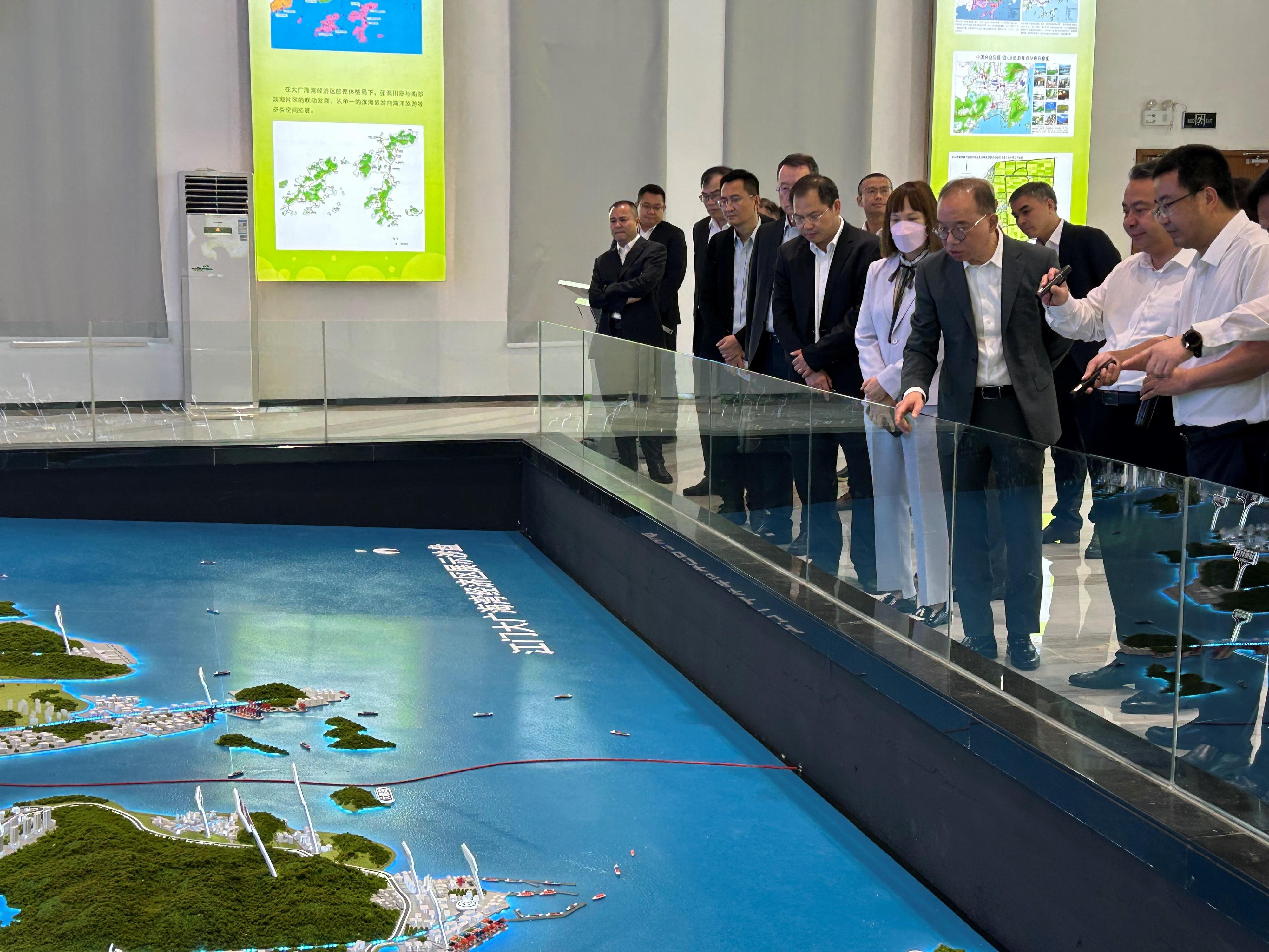 The Secretary for Constitutional and Mainland Affairs, Mr Erick Tsang Kwok-wai (third right), visits Jiangmen today (August 11) and is being briefed by the Member of the Standing Committee of the CPC Jiangmen Municipal Committee Mr Li Huiwen (second right) at the exhibition hall of the Administrative Committee of the Guanghaiwan economic development zone. Also attending is the Commissioner for the Development of the Guangdong-Hong Kong-Macao Greater Bay Area, Ms Maisie Chan (fourth right).