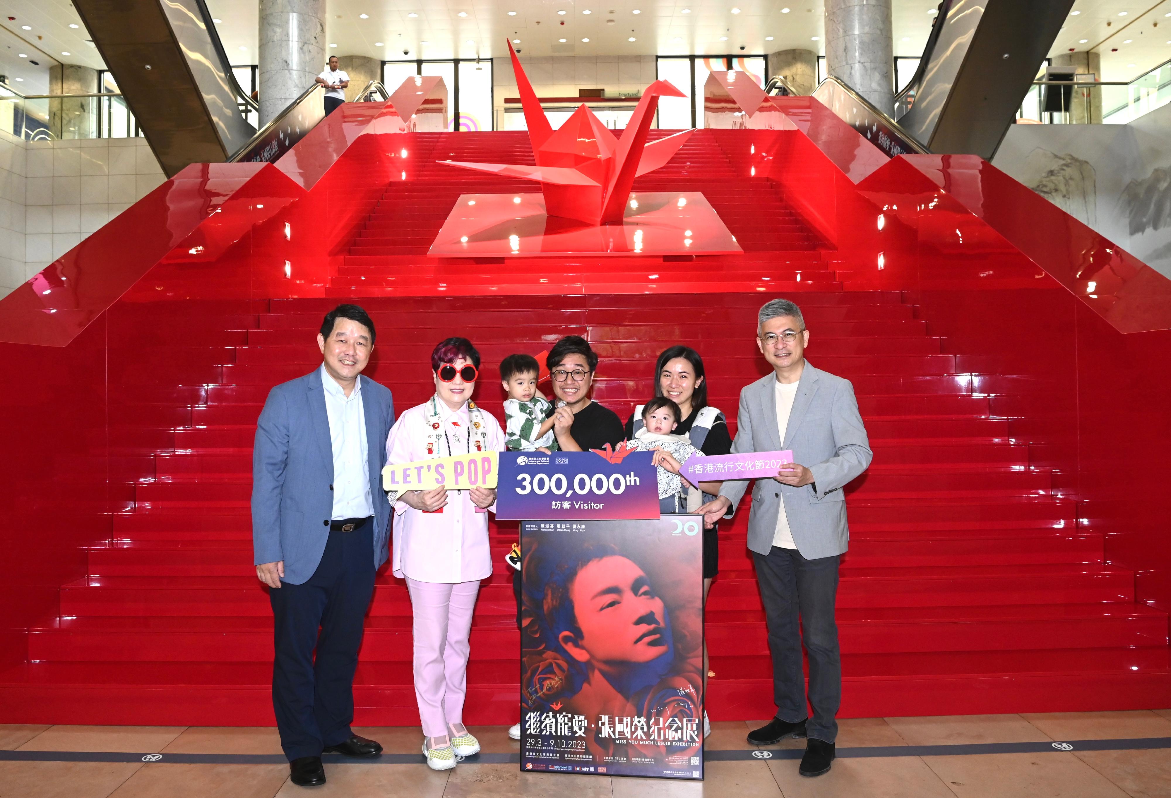Hong Kong Heritage Museum's "Miss You Much Leslie Exhibition" has received overwhelming public response since its opening. The exhibition received its 300 000th visitor today (August 13). Photo shows the Under Secretary for Culture, Sports and Tourism, Mr Raistlin Lau (first right); one of the guest curators of the exhibition Ms Florence Chan (second left); and the Museum Director (Heritage Museum), Mr Brian Lam (first left), welcoming the 300 000th visitor, and presenting to the visitor an exhibition poster with autographs of the three guest curators, complimentary tickets for Hong Kong Film Archive's film screening programme "Revisiting the Glory Days - The Legacy of Leslie and Anita", Leslie Cheung's 20th Anniversary Antique Rose Commemorative Medal and a gift pack of "Hong Kong Pop 60+".