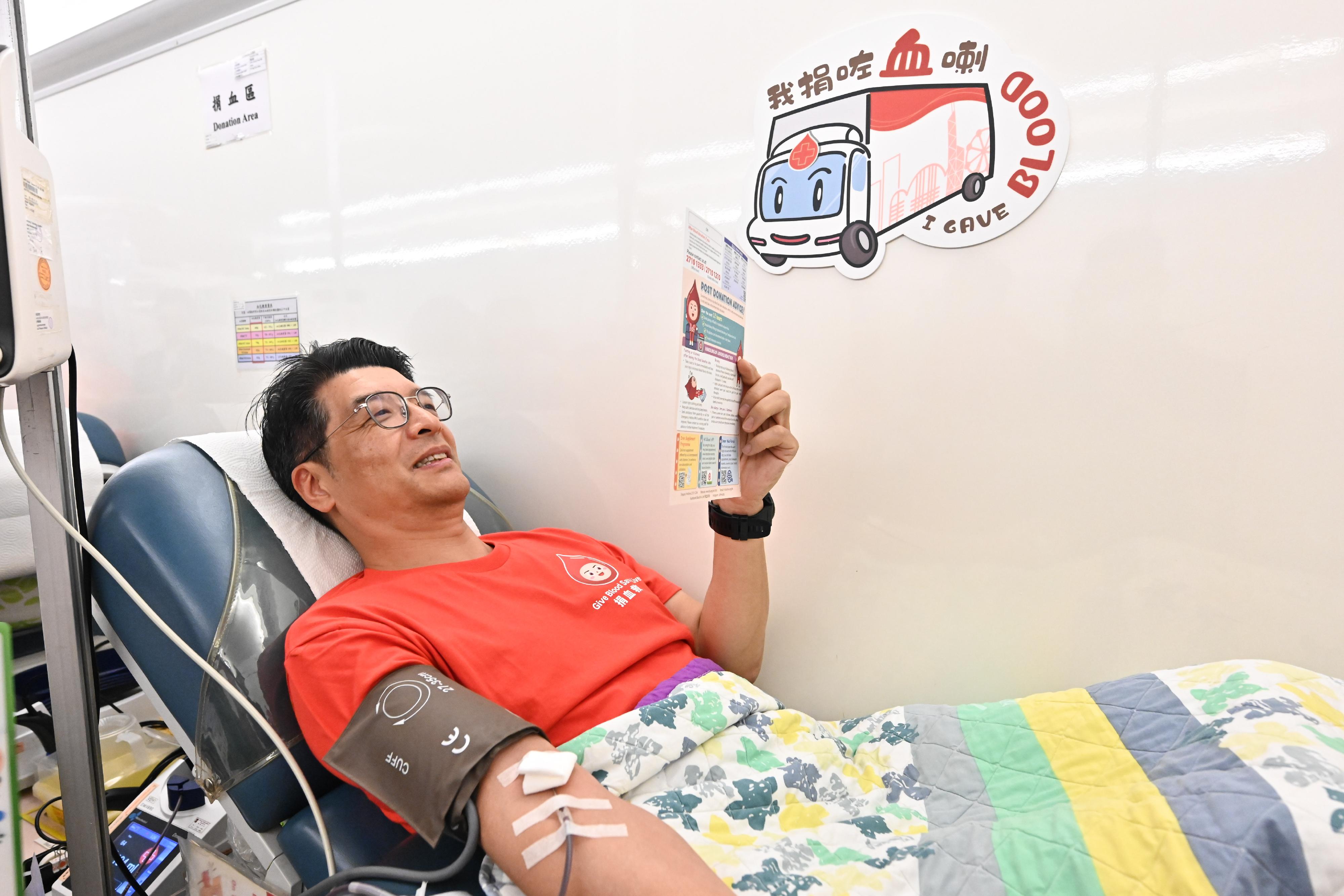 The Commissioner for Primary Healthcare of the Health Bureau, Dr Pang Fei-chau, donates blood on the mobile blood donation vehicle of the Hong Kong Red Cross Blood Transfusion Service parked at the Central Government Offices today (August 14).